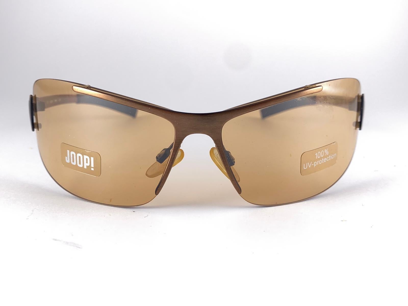 







New Vintage Joop! 1990'S Mod 8621 Copper Frame Shield  Sunglasses Made In Germany

Spotless Gold Slight Mirror Lenses.

New, Never Worn Or Displayed.

This Item May Show Minor Sign Of Wear Due To Storage.

Front : 17 Cms
Lens Height : 4