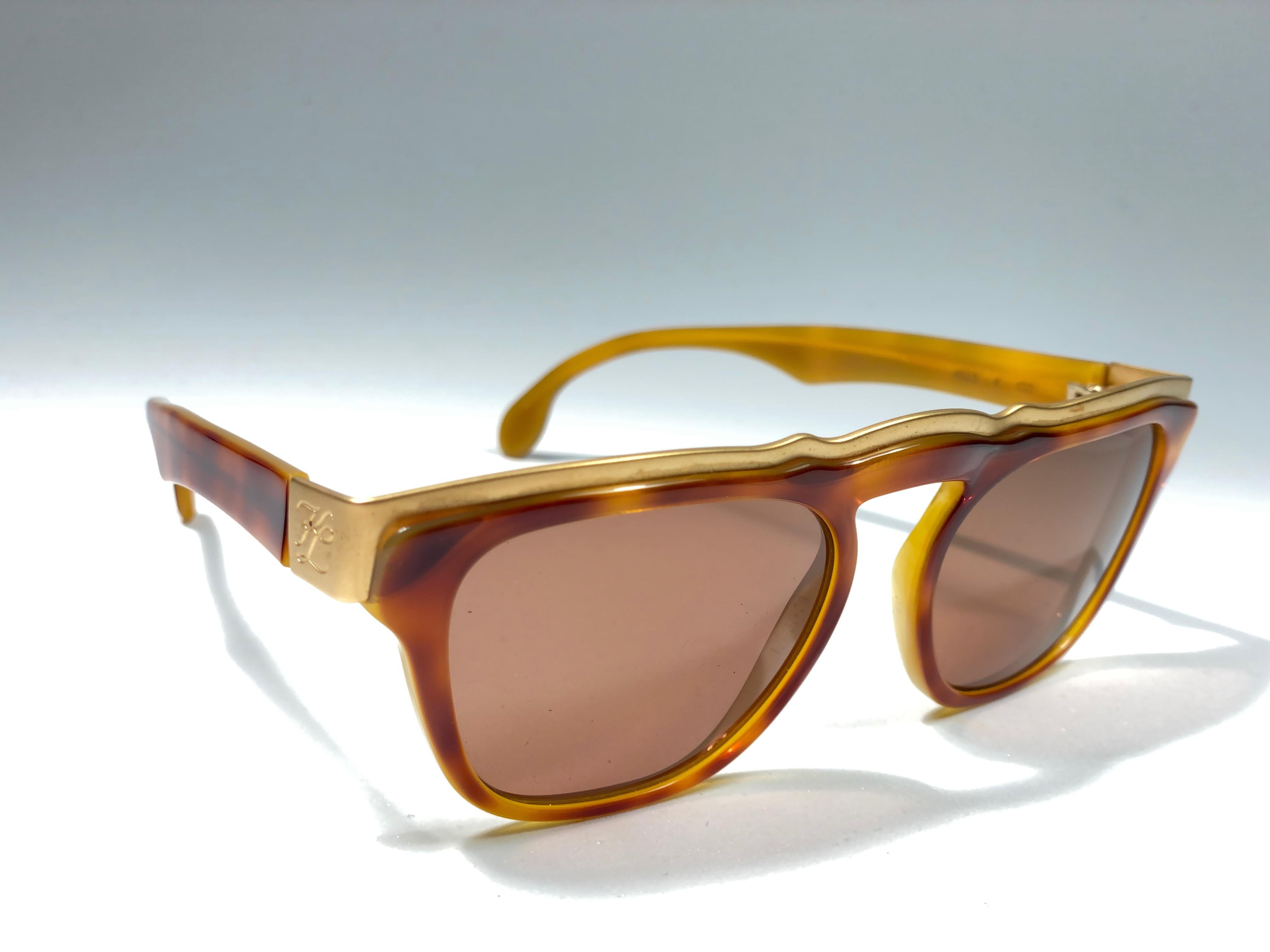 Amazing pair of New vintage 1980's Karl Lagerfeld gold & brown mosaic sunglasses framing a pair of amber lenses.
 
 New, never worn or displayed. This pair may show minor sign of wear due to storage. A true fashion statement .