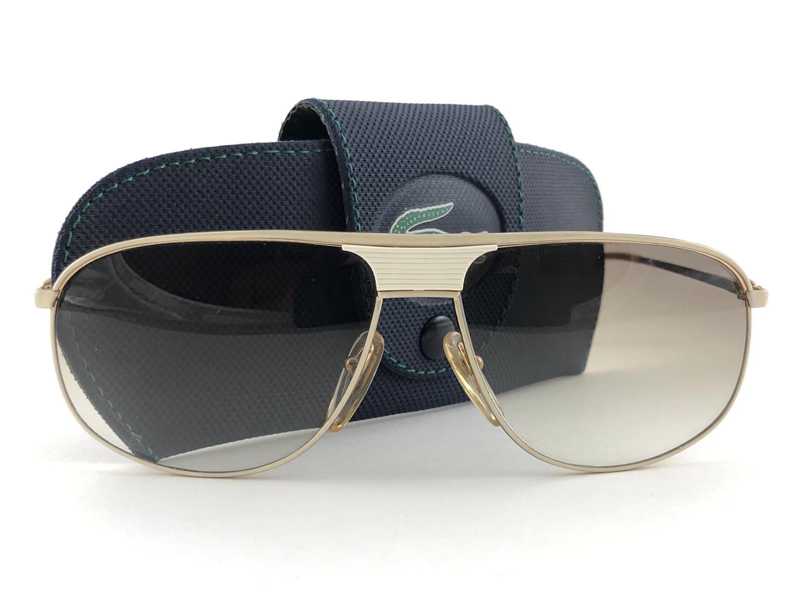 New Vintage Lacoste white with beige accents frame holding a pair of gradient brown lenses. 
This pair may have minor sign of wear on the lens due to storage. 
New, never worn or displayed. 
Design and produced in France.

MEASUREMENTS

FRONT : 14