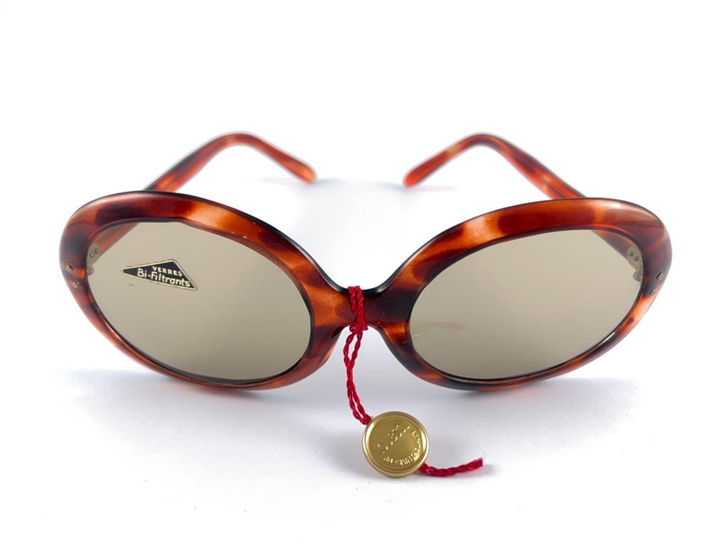 New vintage Loubsol oversized tortoise sunglasses with medium light brown lenses.

New Never Worn Or Display, This Item May Show Minor Sign Of Wear Due To Storage

Made In France.

Front                                    16.5 Cms 

Lens Height     
