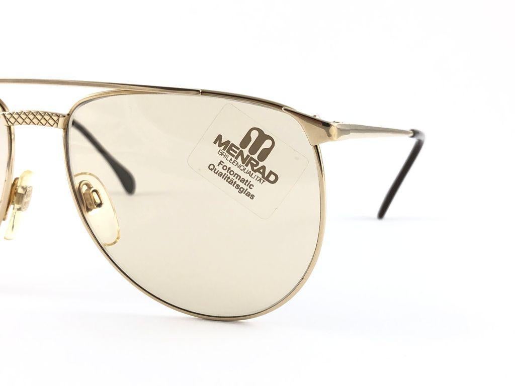 New Vintage Collector Item Menrad M743 Gold Aviator Cadre surdimensionné portant une paire de lunettes légères  Fotomatic  lentilles.  

Fabriqué en Allemagne dans les années 1970.


Front :                      14 cm 

Hauteur de l'objectif :      