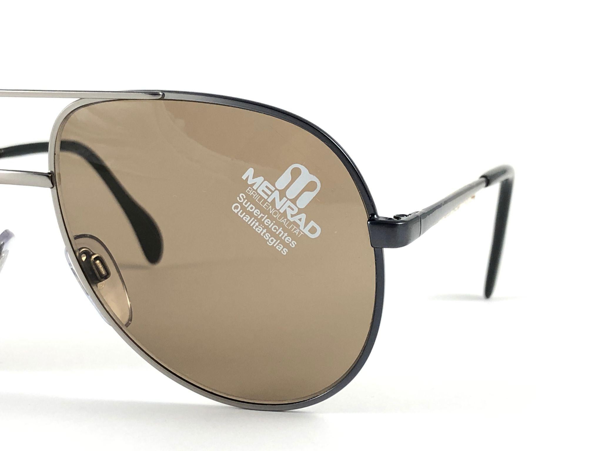 New Vintage Collector Item Menrad silver Sunglasses frame holding a pair of light  lentilles.  

Fabriqué en Allemagne dans les années 1970.


Devant : 14 cms 

Hauteur de l'objectif : 5,3 cm 

Largeur de l'objectif : 5,5 cm 

Temples : 12 cms
