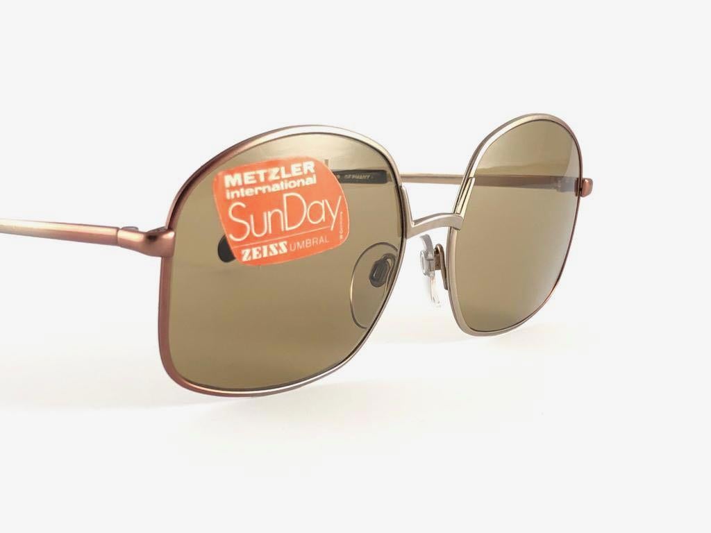 Made in West Germany 1980's. 

Oversized Metallic rose and silver frame holding a spotless pair of medium brown lenses.

MEASUREMENTS:

Front :                      13.5 cms
Lens Height :            5 cms
Lens Width :          5.5 cms
Temples :     
