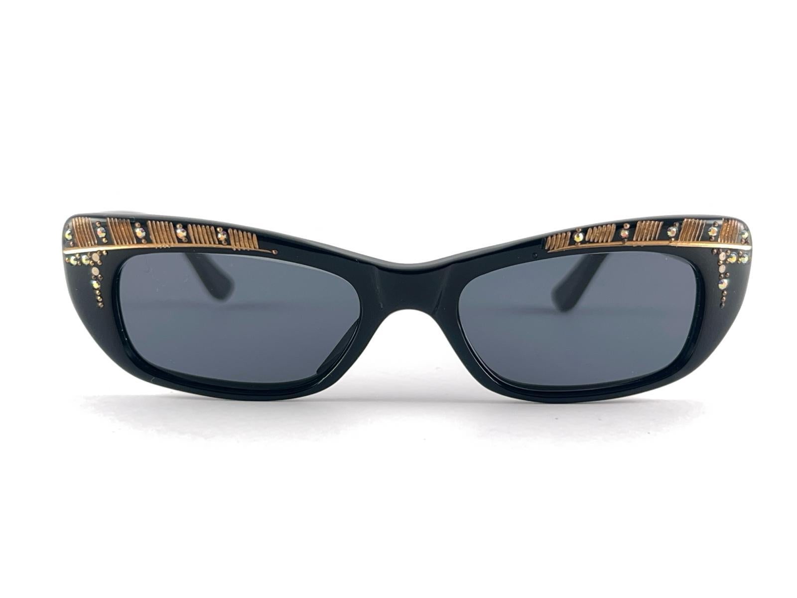 
New Vintage Midcentury Traviata Small Black, Rhinestones and Gold accents Frame holding a pair of medium are lenses.

Neuf, jamais porté ni exposé, cet article peut présenter de légers signes d'usure dus à plus de 50 ans de stockage.



Fabriqué en