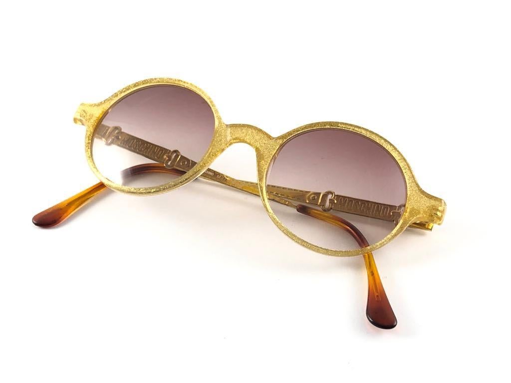 New Vintage Moschino medium size round frame. Spotless gradient mauve lenses.

Made in Italy.
 
Produced and design in 1990's.

This item may show minor sign of wear due to storage.

FRONT 13.5 CMS

LENSE HIGHT 4 CMS

LENSE WIDTH 4 CMS

TEMPLE 13 CMS