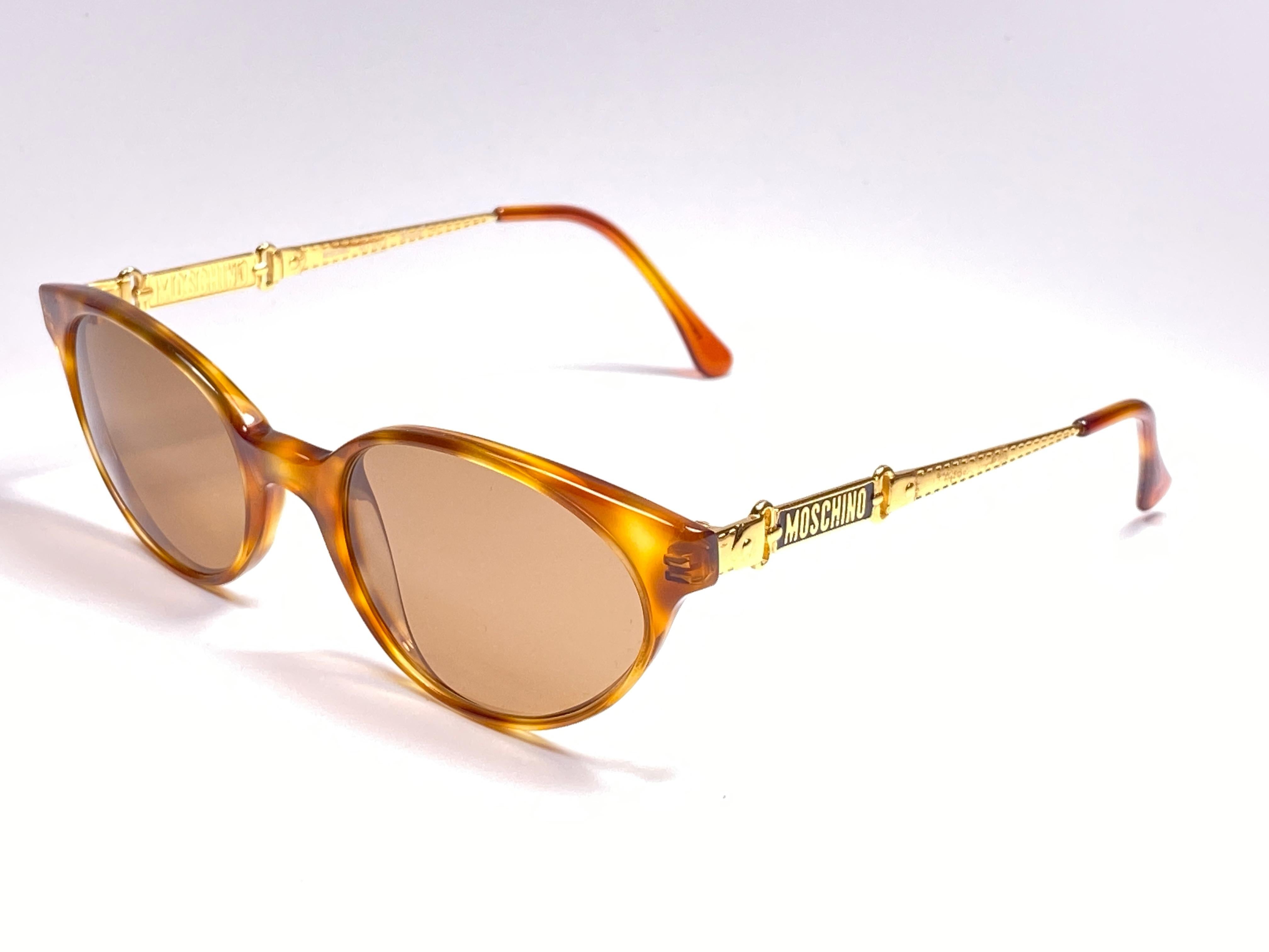 New Vintage Moschino tortoise Cat Eye medium size gold frame

Spotless medium brown lenses.

Made in Italy.
 
Produced and design in 1990's.

This item may show minor sign of wear due to storage.

Front : 14 cms 
Lens Width : 5 cms
Lens Height : 3.2