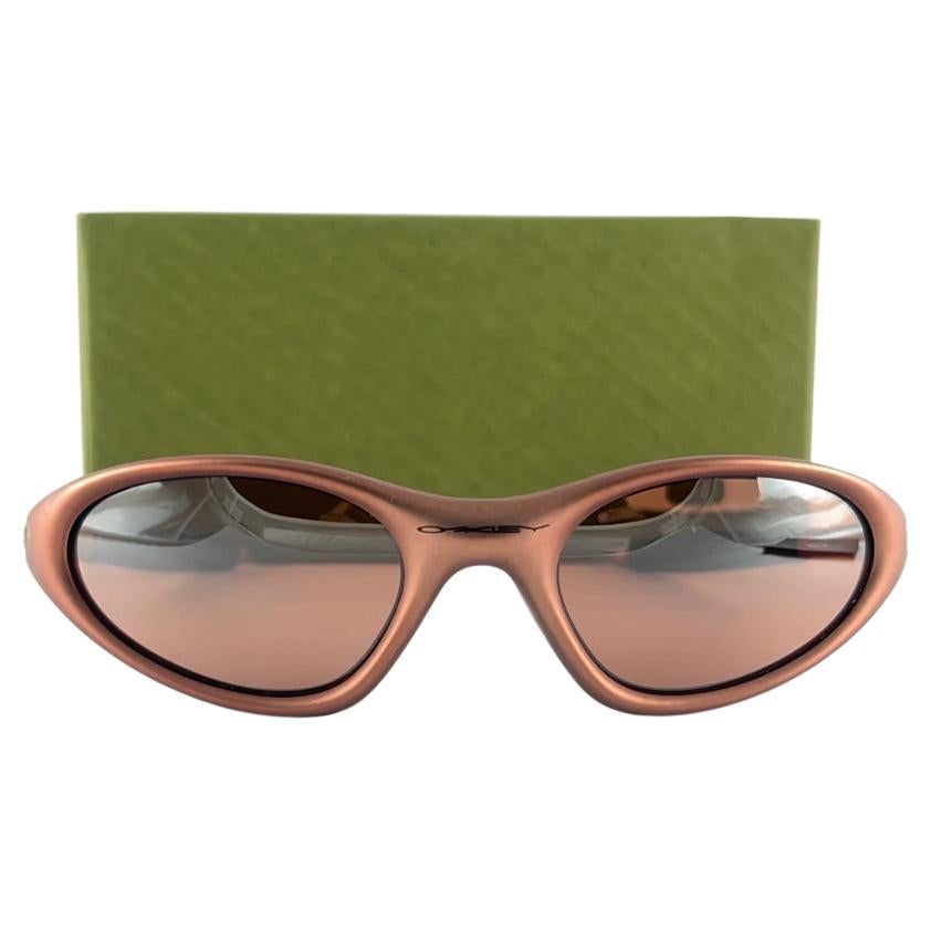 
New Vintage Oakley Minute metallic copper Frame Sunglasses. Wrap frame with grey mirror lenses.
New never worn or displayed. This item might show minor sign of wear due to storage.
Comes with its original box and papers as pictured.
Made in Usa