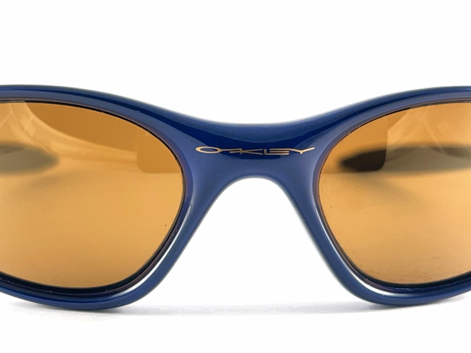 
New Vintage Oakley Minute Sonnenbrille. Metallicblauer Sportrahmen mit polarisierten mittelbraunen Gläsern.
Neu, nie getragen oder ausgestellt. Dieser Artikel kann aufgrund der Lagerung leichte Gebrauchsspuren aufweisen.

Hergestellt in Usa