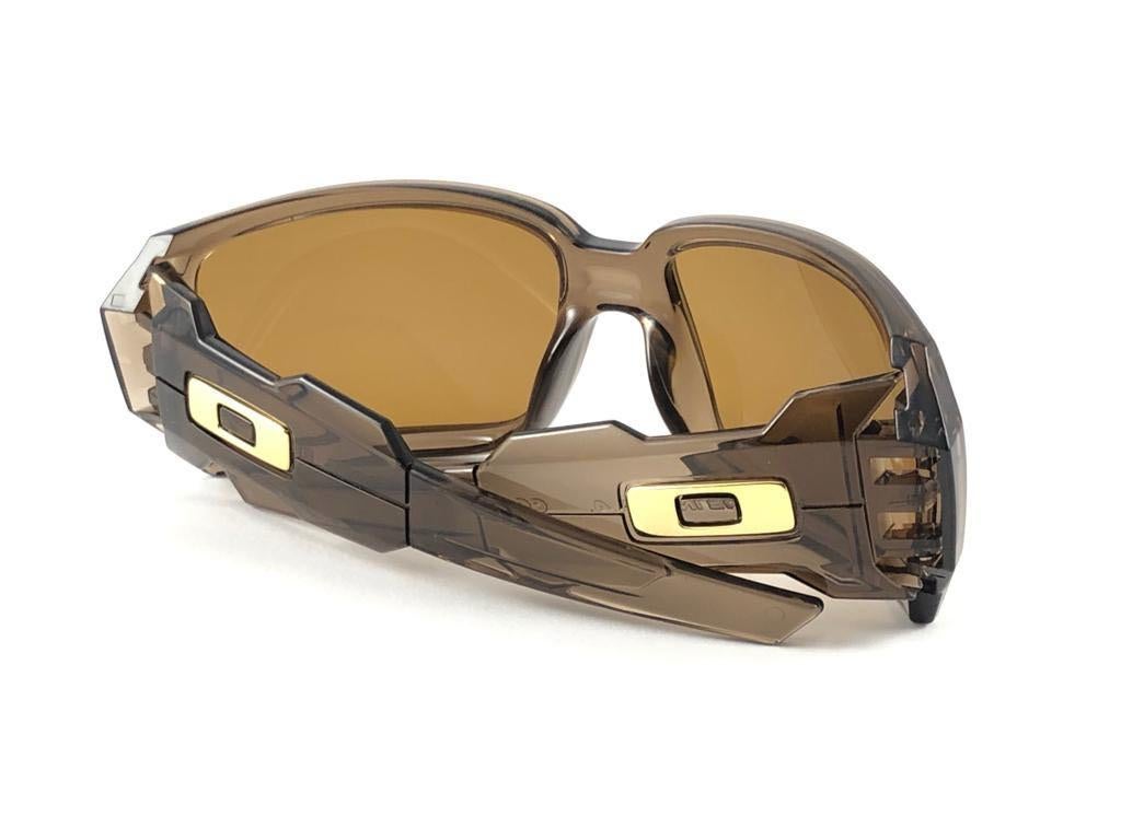 
New Vintage Oakley Oil Drum Frame Sunglasses. Wrap Brown Smoke frame with bronze  lenses.
New never worn or displayed. This item might show minor sign of wear due to storage.
Comes with its original box and papers as pictured.
Made in Usa