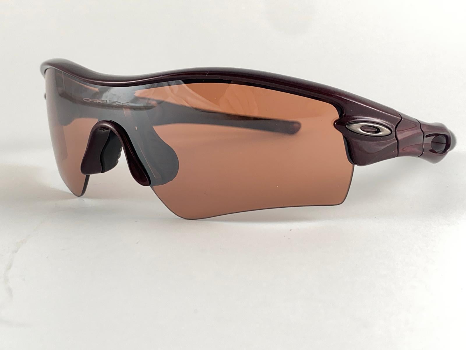 
New Vintage Oakley Radar Burgundy Sunglasses. Wrap around burgundy sports frame with medium rose lenses.
New never worn or displayed. This item might show minor sign of wear due to storage.

Made in Usa