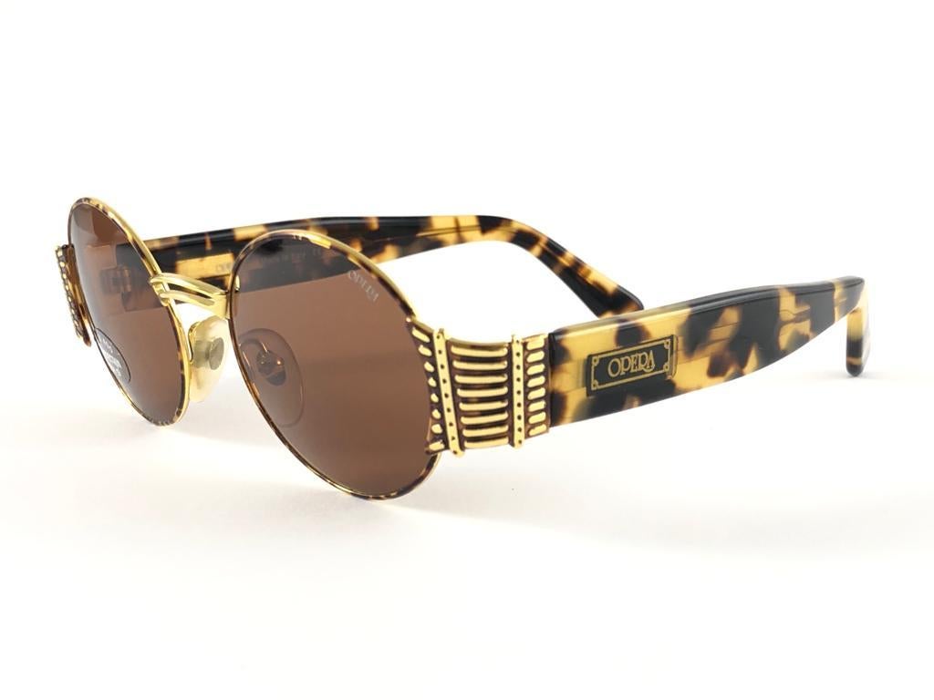 New Opera tortoise and gold oval frame with solid brown ( UV protection ) lenses.

Made in Italy.
 
Produced and design in 1990's.

New, never worn or displayed. this  item may show minor sign of wear due to storage.

FRONT                   13  