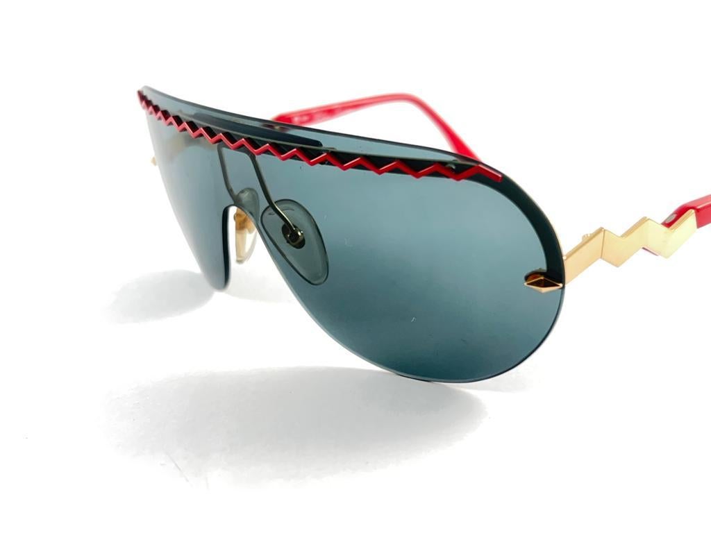 Vintage Paloma Picasso Sonnenbrille Made in Germany 1980'S.   

Red Shield Frame hält eine schöne Mono Linse in Medium grau. 

Die Linsen weisen kleine Kratzer auf den Linsen auf.   

Hergestellt in Deutschland.


Messungen


Vorderseite            
