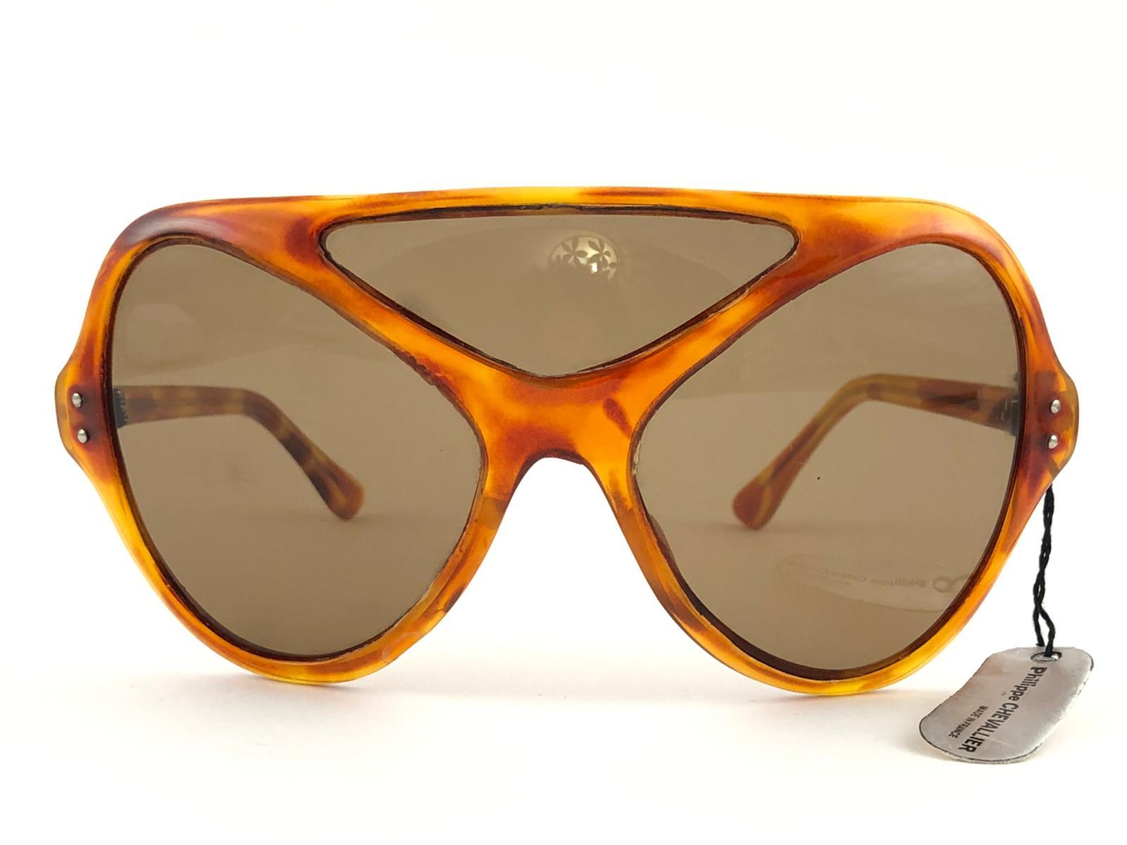 Nouvelles lunettes de soleil vintage Philippe Chevalier, pièce de collection rare, de taille surdimensionnée en écaille de tortue légère, avec trois verres marron moyen sans tache. De la même série que ceux portés par Miles Davis.
Une superbe