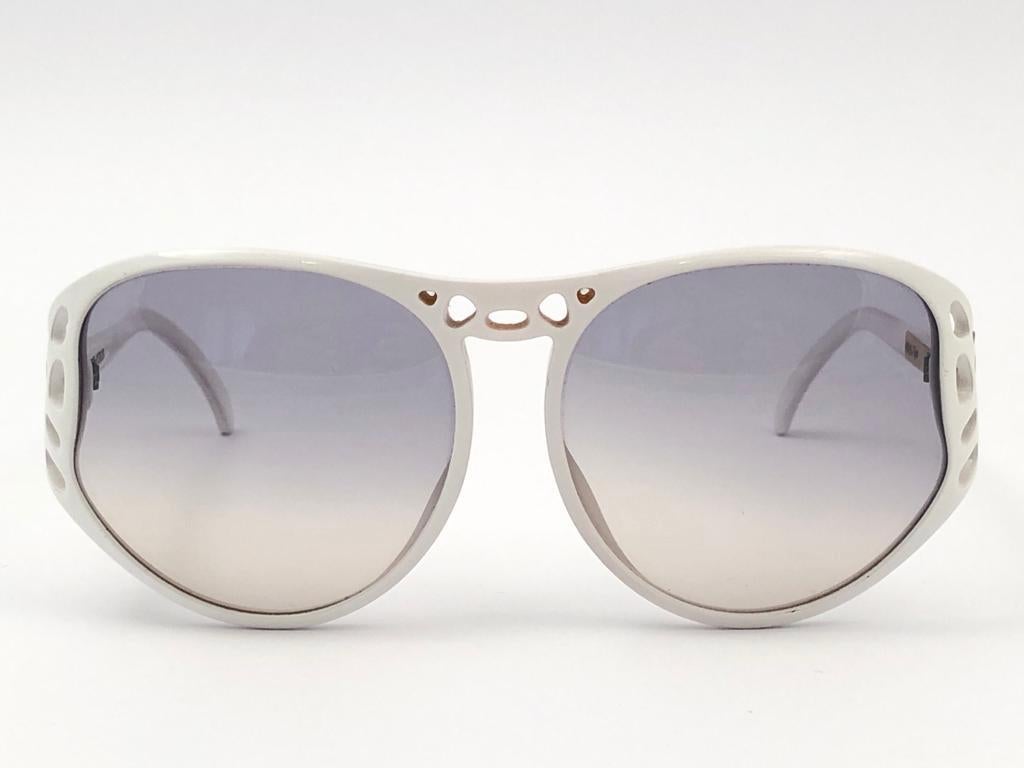 New Vintage Playboy Optyl 4543 oversized white frame sporting spotless light blue gradient lenses. 

Made in Austria.
 
Produced and design in 1970's.


FRONT : 14 CMS

LENS HEIGHT : 5.5 CMS

LENS WIDTH : 5.8 CMS

TEMPLES : 12 CMS

New, never worn