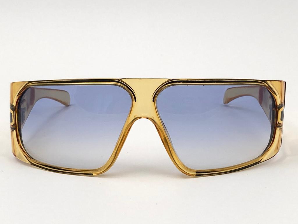 New Vintage Playboy Optyl  translucent yellow frame sporting spotless blue gradient lenses. 

Made in Germany.
 
Produced and design in 1970's.


FRONT : 15 CMS

LENS HEIGHT : 4.2 CMS

LENS WIDTH : 6.2 CMS

TEMPLES : 11.5 CMS

New, never worn or