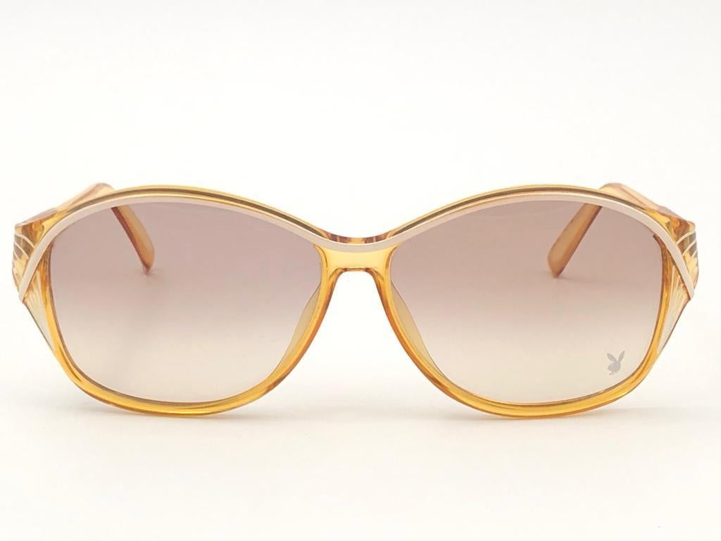 New Vintage Playboy Optyl 4559 oversized translucent and beige frame sporting spotless light gradient lenses. 

Made in Germany.
 
Produced and design in 1970's.



FRONT : 15 CMS

LENS HEIGHT : 5.5 CMS

LENS WIDTH : 6 CMS

TEMPLES : 12 CMS

New,