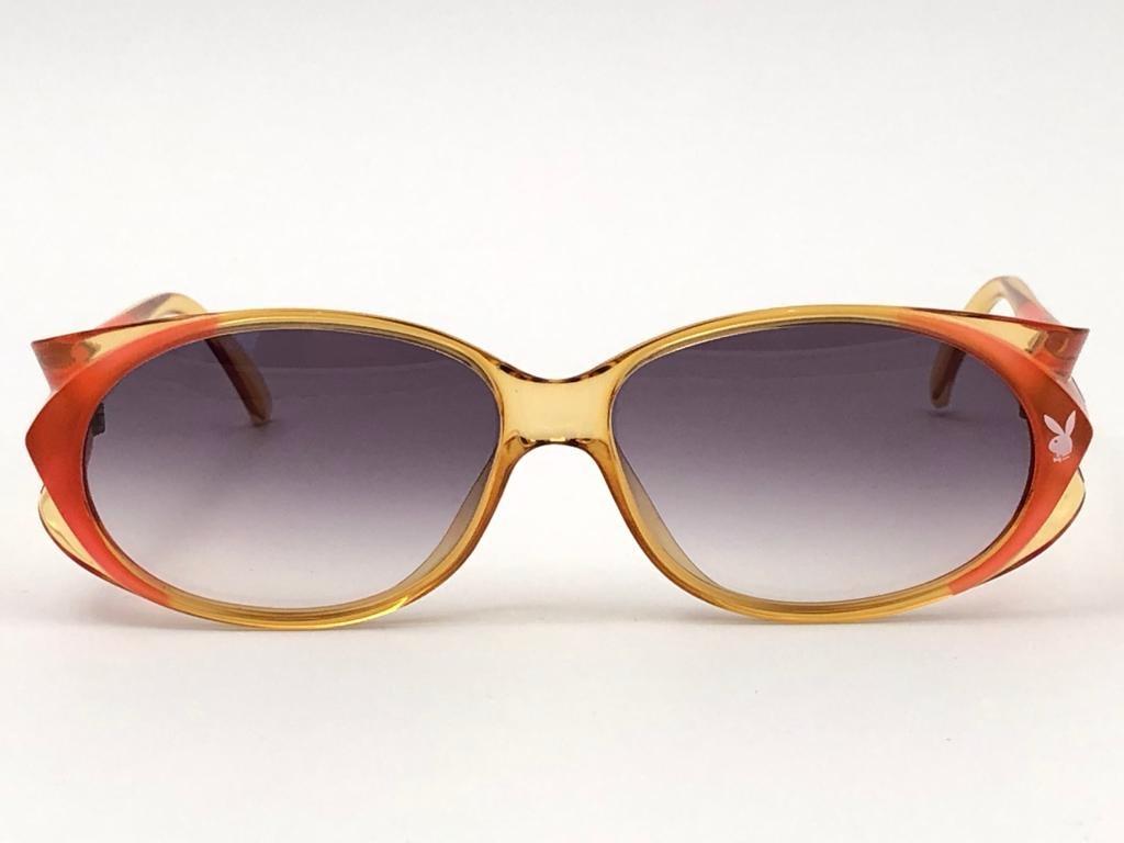 New Vintage Playboy Optyl 4560 translucent amber and orange frame sporting spotless light blue gradient lenses. 

Made in Austria.
 
Produced and design in 1970's.


FRONT : 14 CMS

LENS HEIGHT : 4 CMS

LENS WIDTH : 5.5 CMS

TEMPLES : 13 CMS

New,