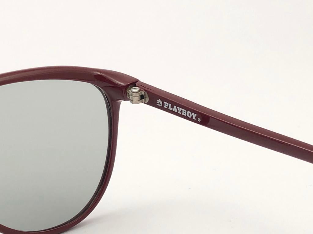 New Vintage Playboy Optyl oversized burgundy frame sporting spotless medium blue lenses. 

Made in Germany.
 
Produced and design in 1970's.


FRONT : 14 CMS

LENS HEIGHT : 5 CMS

LENS WIDTH : 5.6  CMS

TEMPLES : 13 CMS

New, never worn or