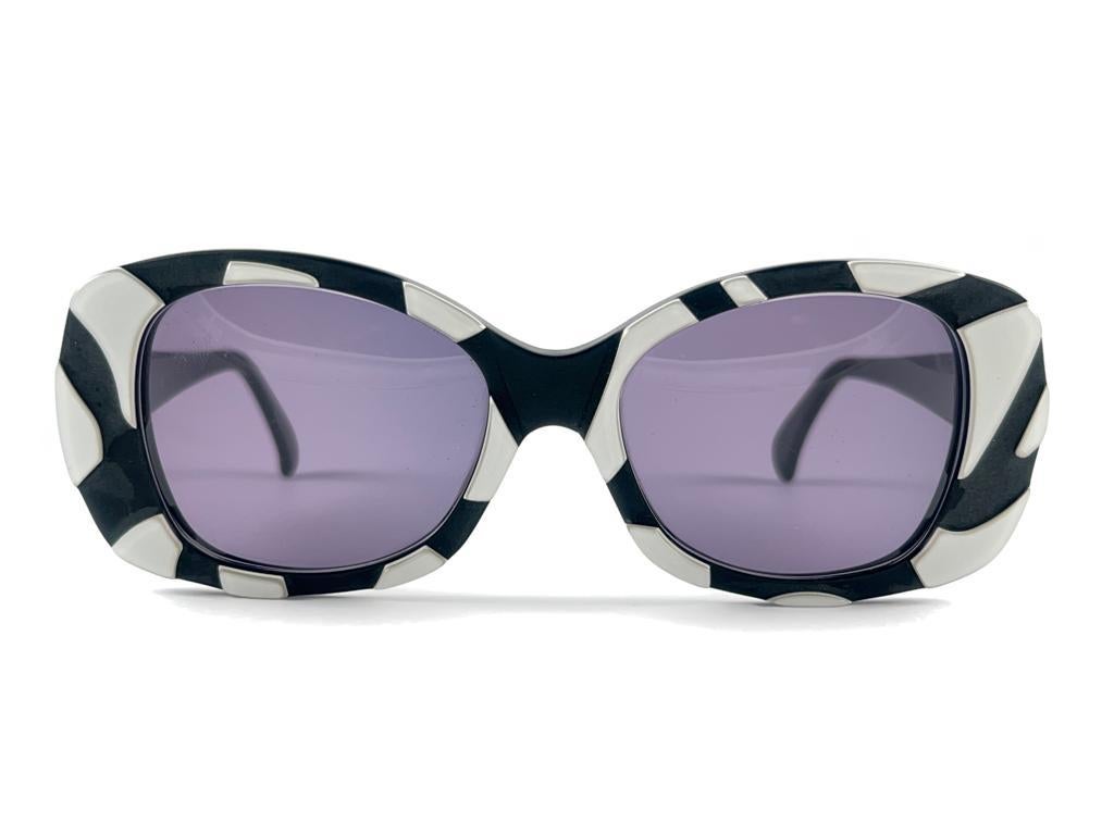 

New 1990’S Alain Mikli Sleek Oversized Black frame White Pearl Lacquered Accents Frame Sporting Medium Purple Lenses. 
This Item May Show Minor Sign Of Wear Due To Storage 
A Real Sought After Piece.



Hand Made in France



Front                
