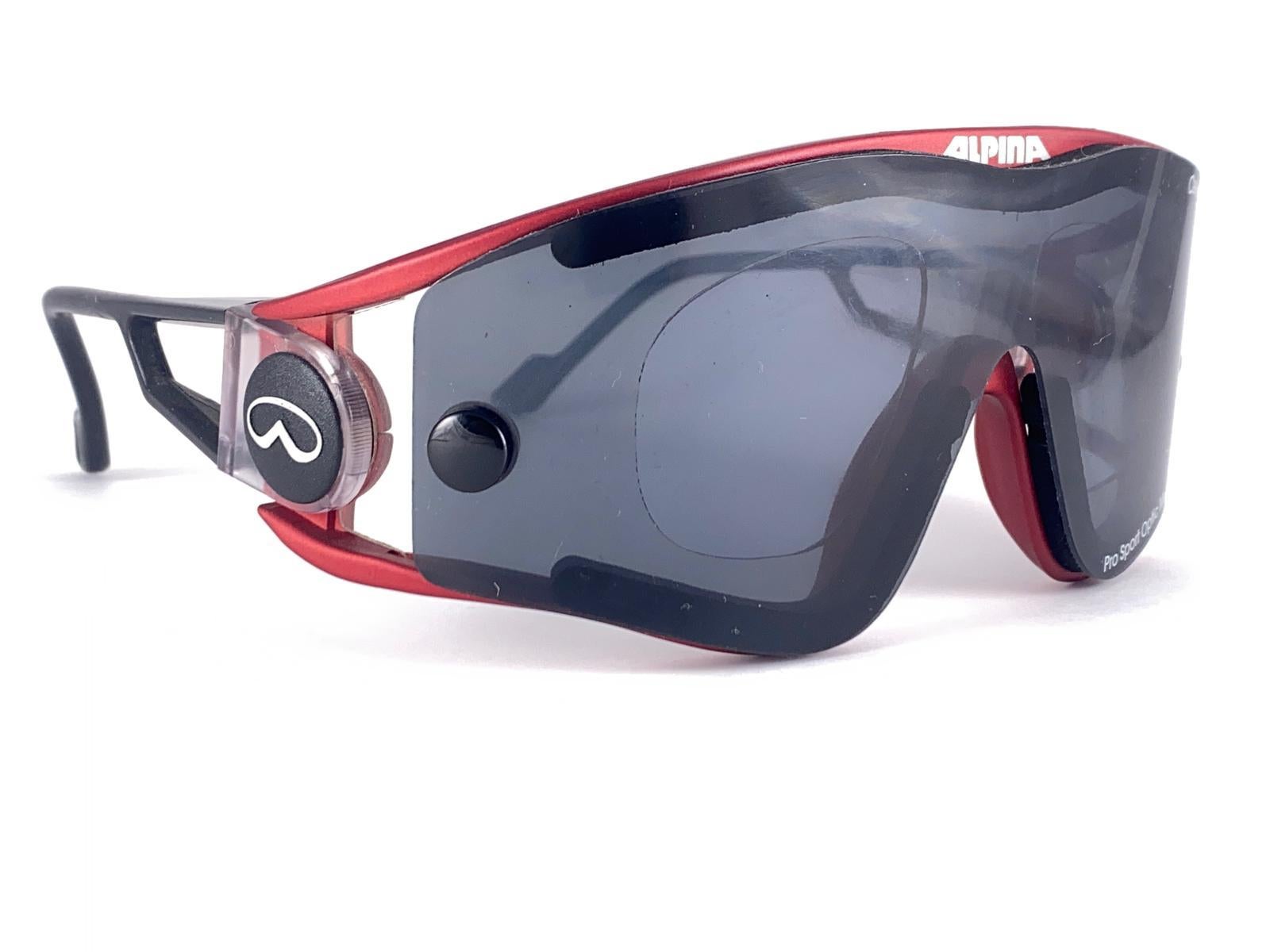 

New Vintage Rare Alpina Pro Sport Optic Sunglasses. Telaio Wrap nero e rosso con lenti mono grigie
Nuovo, mai indossato o esposto. 
Questo articolo presenta lievi segni di usura sulle lenti a causa della conservazione.

Prodotto in