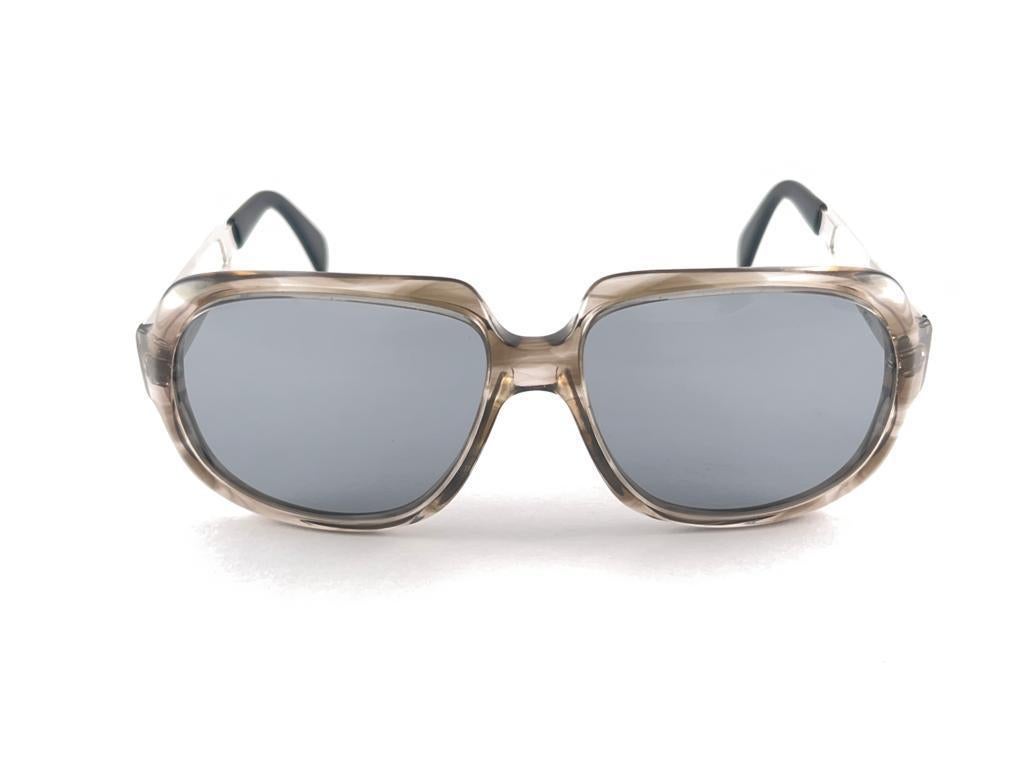 New Vintage Menrad Sunglasses. Monture en acétate et métal, fraîche et robuste, portant une paire de lentilles gris moyen 
Une qualité étonnante, un look superbe 
Cet article peut présenter des signes mineurs d'usure dus à 30 ans de