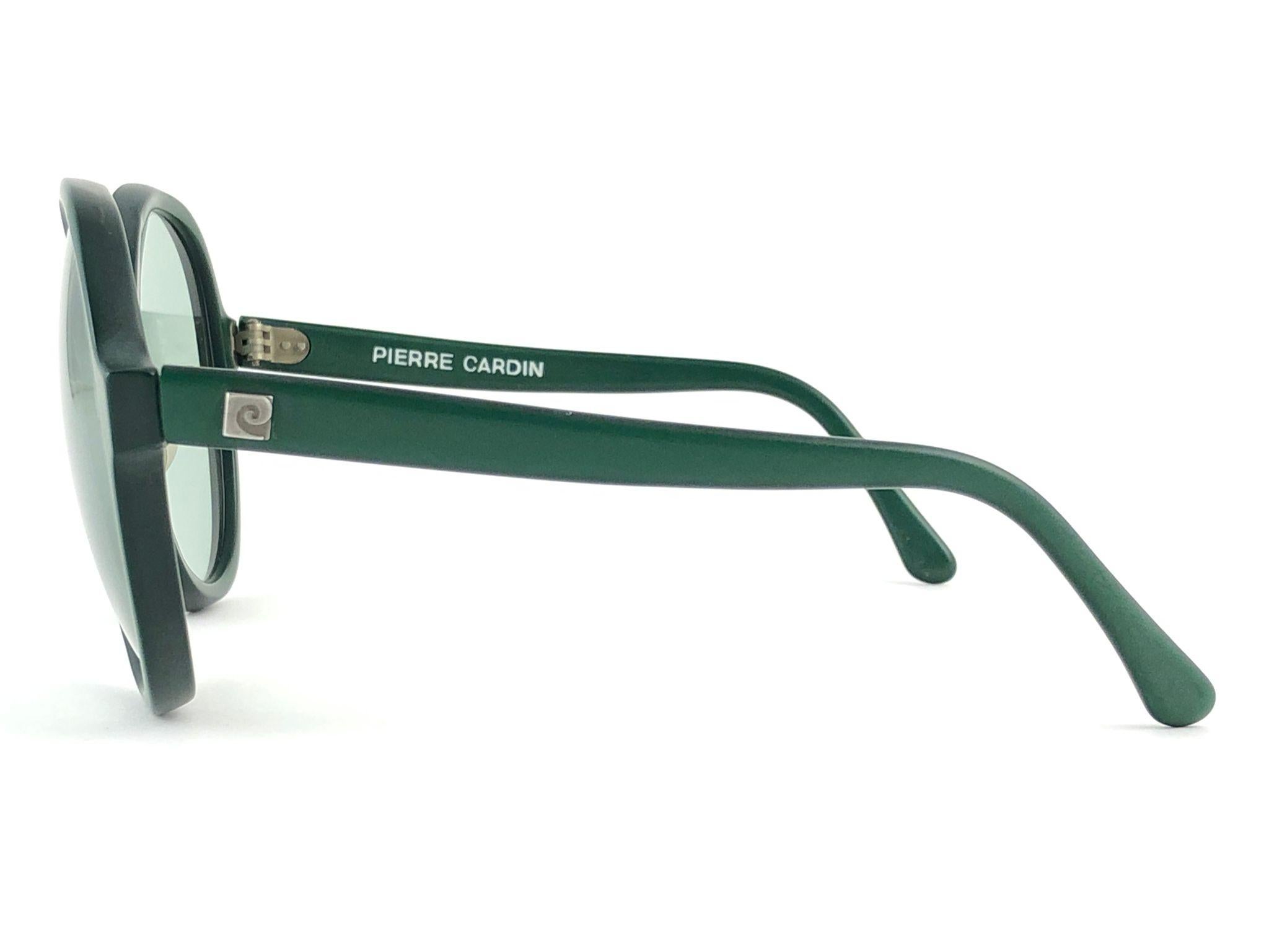 New vintage futuristic Pierre Cardin oversized dark green frame sporting a beautiful pair of medium green lenses.
This pair have minor wear on them due to to nearly 60 years of storage and some letters have fade on the temple. Please study the