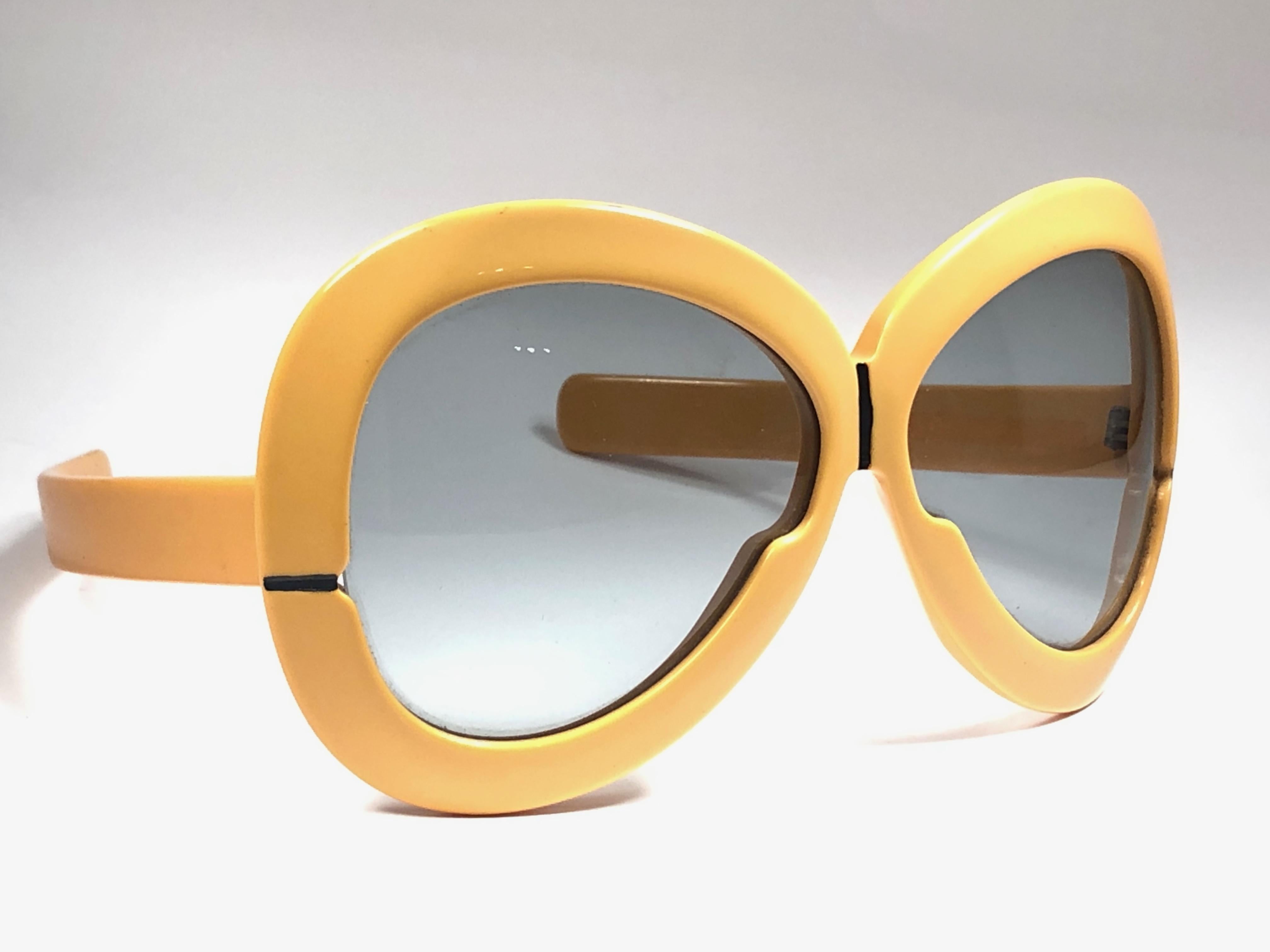 New Vintage Collector Item Silhouette Futura 561 ochre thick frame with holding a spotless pair of light lenses.   

Designed by Dora Demmel in 1973, this rare piece is the epitome of avant garde & futuristic eye wear fashion.

Made in Germany in
