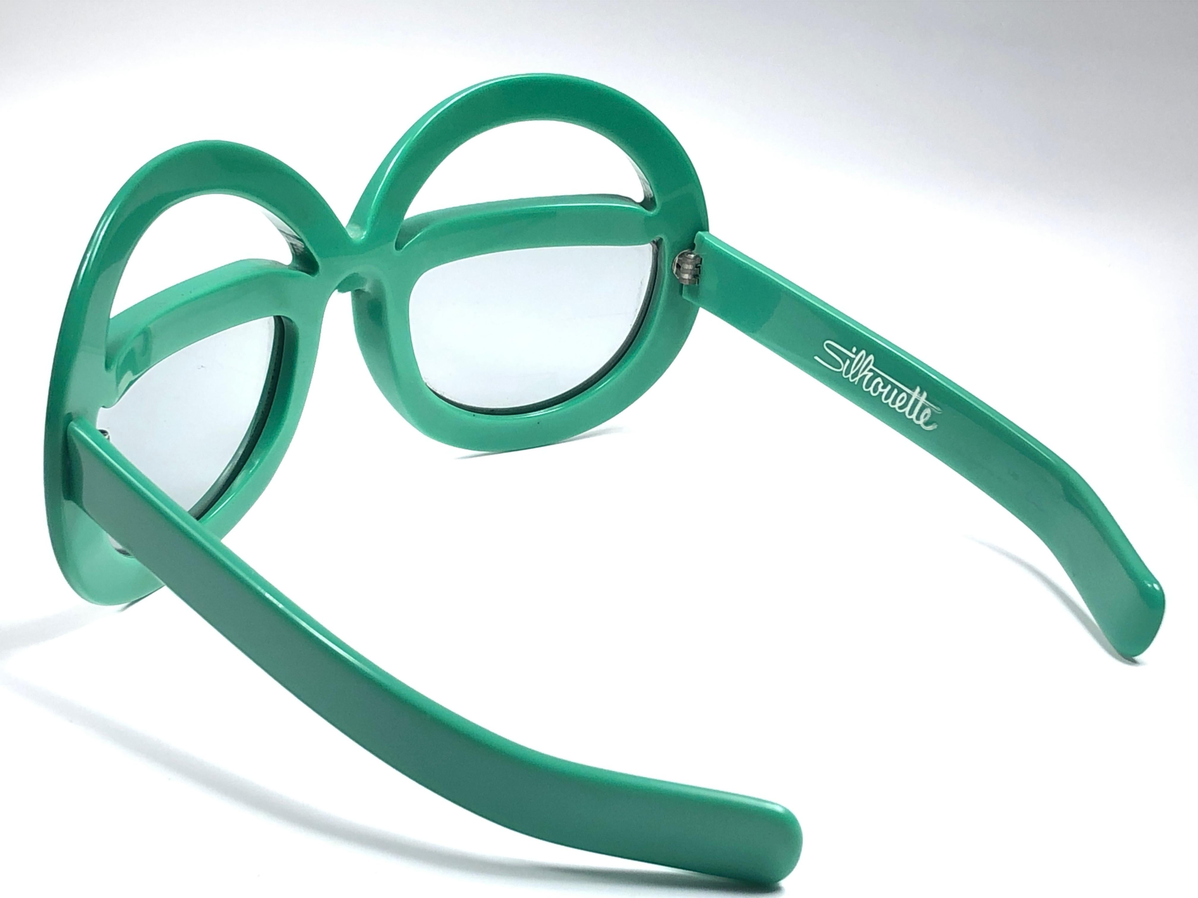 New Vintage Collector Item Silhouette Futura 562 green thick frame with holding a spotless pair of light lenses.   

Designed by Dora Demmel in 1973, this rare piece is the epitome of avant garde & futuristic eye wear fashion.

Made in Germany in