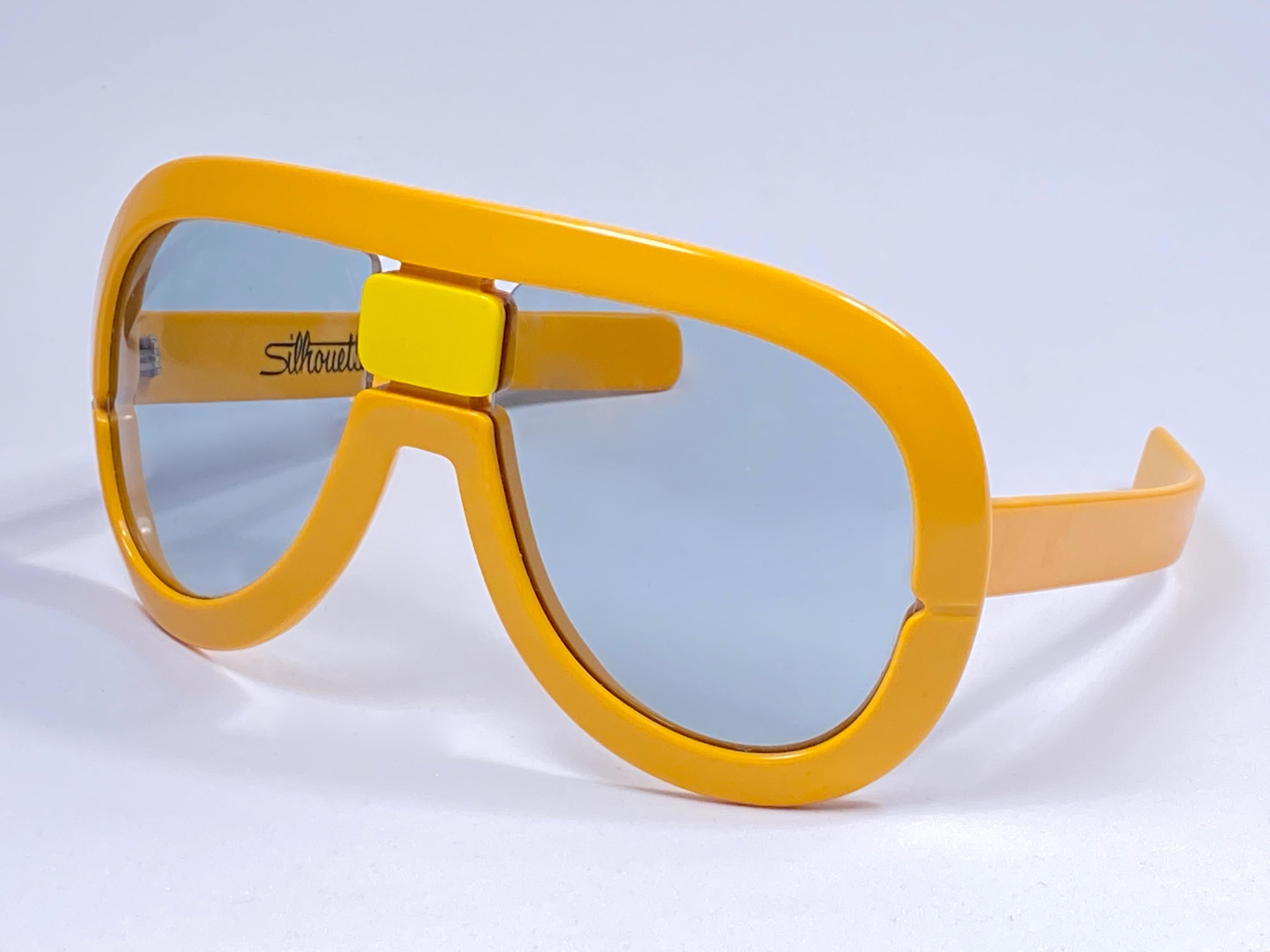 New Vintage Collector Item Silhouette Futura 563 Yellow thick frame with holding a spotless pair of light lenses.   

Designed by Dora Demmel in 1973, this rare piece is the epitome of avant garde & futuristic eye wear fashion.

Made in Germany in