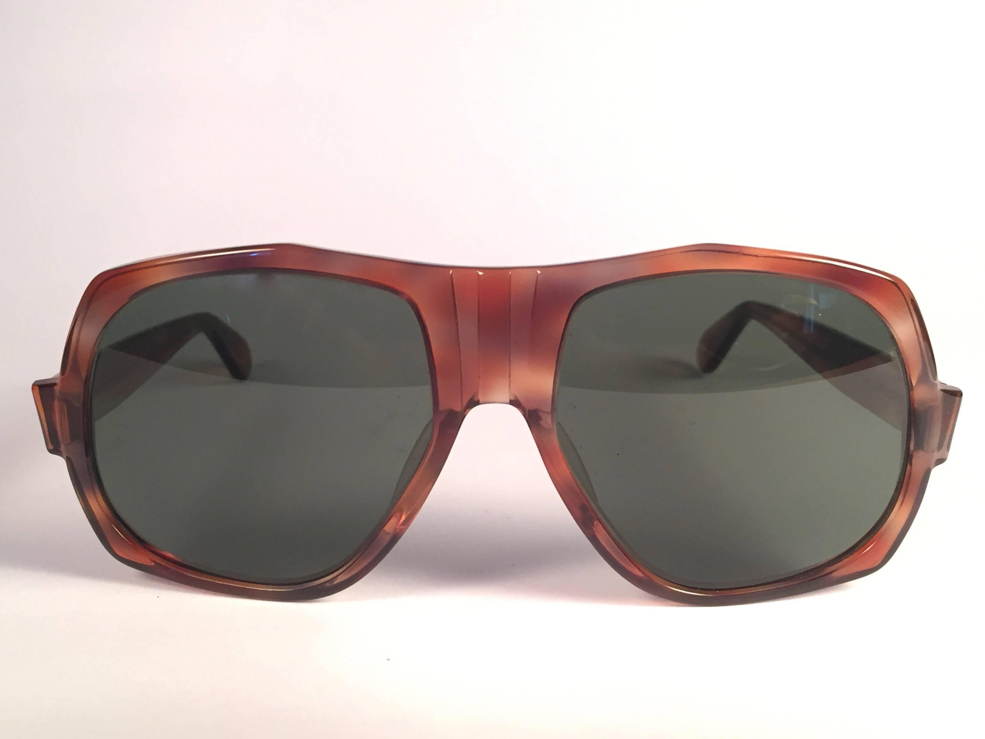 Rare Vintage Bradshaw frame holding a spotless pair of G15 grey lenses.  

This pair may have minor sign of wear due to nearly 40 years of storage. 

Designed and Produced in USA.

FRONT : 14.5 CMS

LENS HEIGHT : 5.4 CMS

LENS WIDTH : 5.6