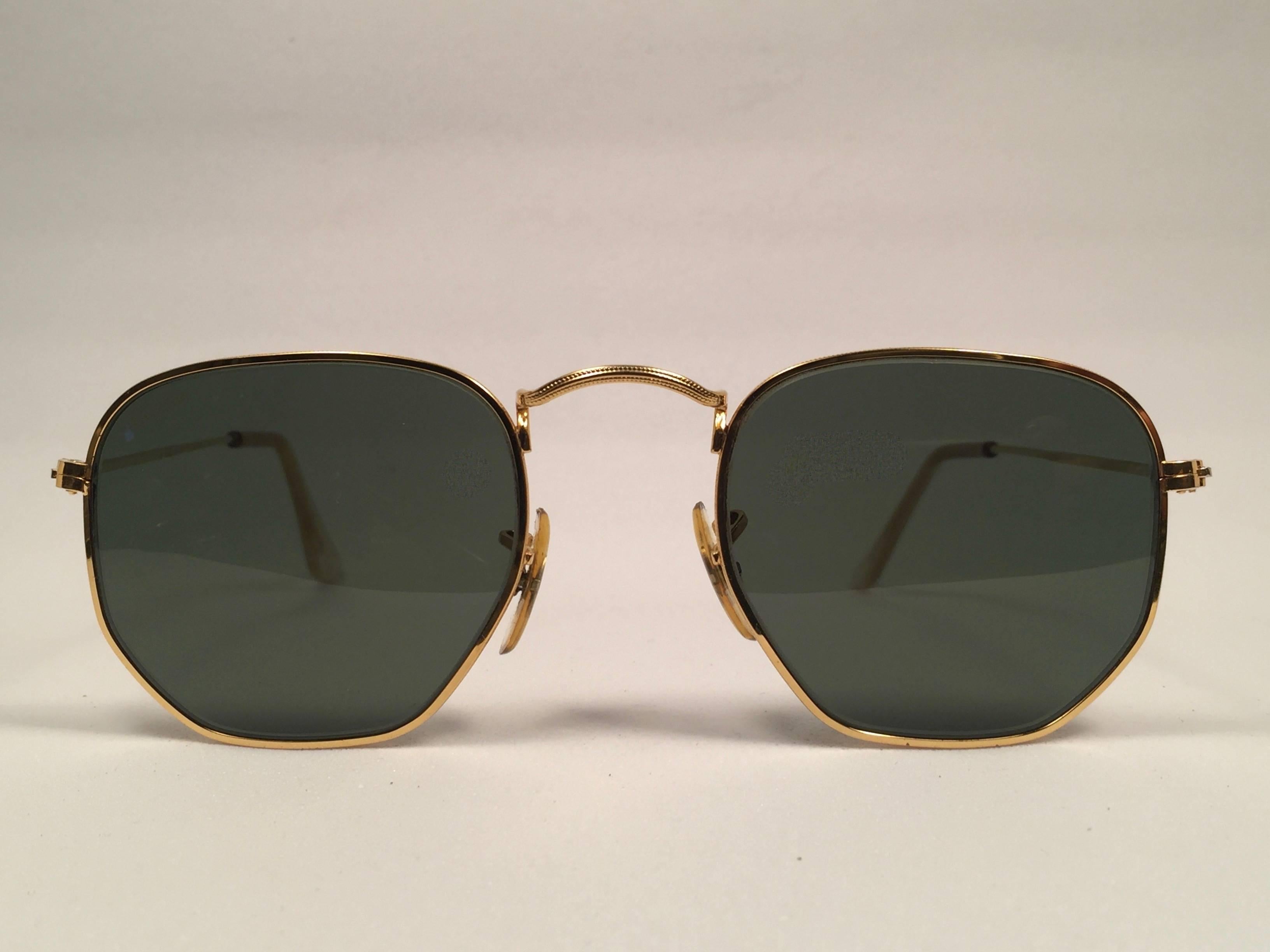 New Vintage Ray Ban classic hexagonal gold sporting G15 grey lenses.
Comes with its original Ray Ban B&L case with minor sign of wear due to storage.  


FRONT 11.5 CMS
LENS HEIGHT 4 CMS 
LENS WIDTH 4.5 CMS 