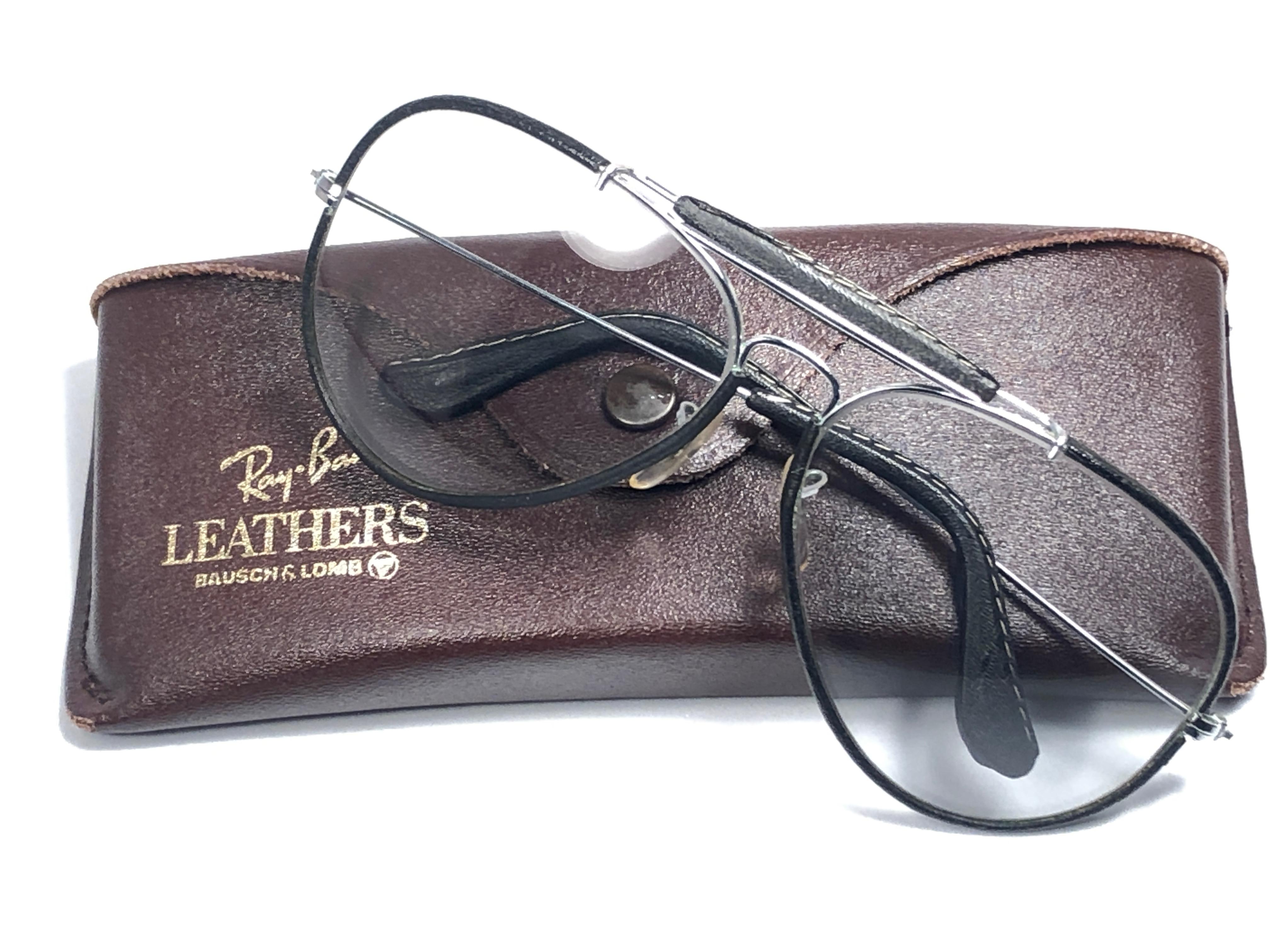 
New Vintage Ray Ban Outdoorsman black 62Mm leather with grey changeable lenses with Ray Ban logo. 

B&L etched in the lenses.

Comes with its original Ray Ban B&L case. Please notice this item may show minor sign of wear due to storage.

Designed