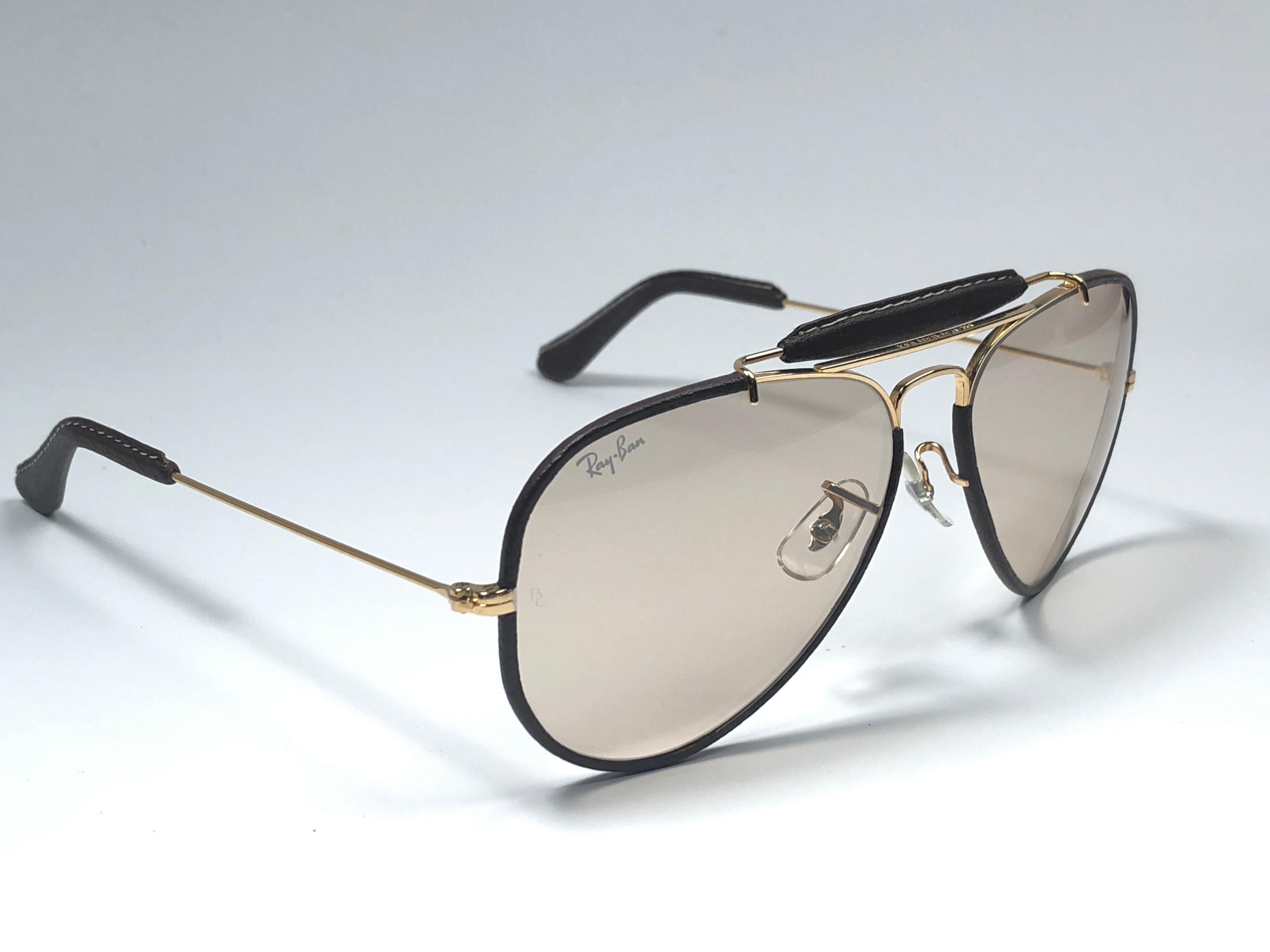 
New Vintage Ray Ban Outdoorsman 58Mm chocolate leather with brown changeable lenses with Ray Ban logo. 

B&L etched in the lenses.

Comes with its original Ray Ban B&L Leathers case, unfortunately we do not have the one depicted on the image.