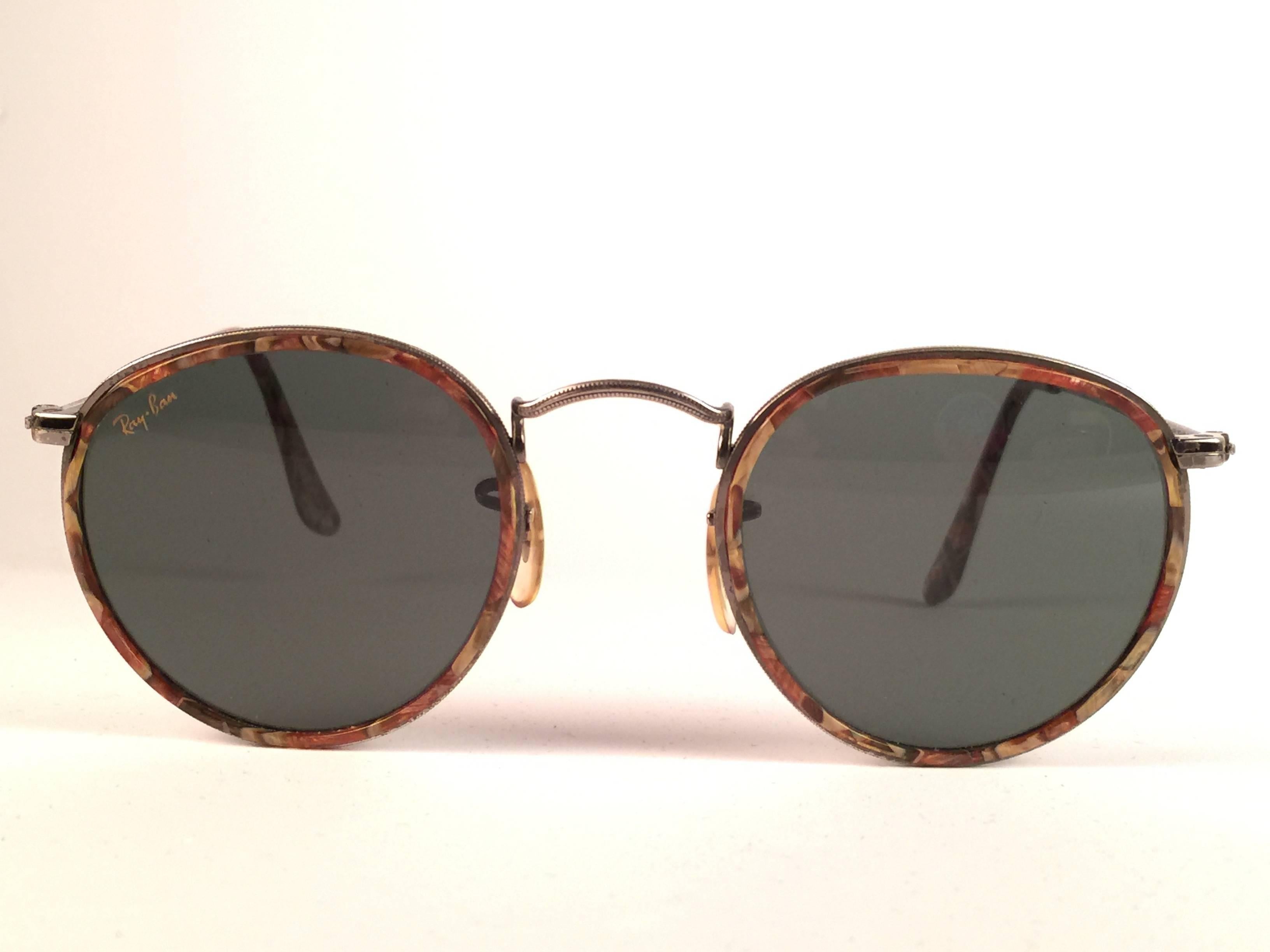 NEW Vintage Ray Ban round copper with mosaic inserts sunglasses. 
Lenses are G15 Grey, B&L etched in the lenses. 
Comes with its original Ray Ban B&L case.  
This piece may show minor sign of wear due to storage on the frame.  

FRONT : 12.5
