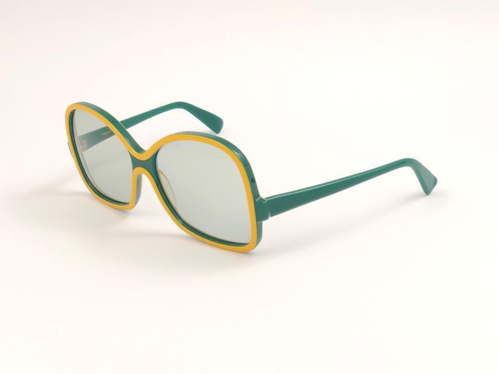 New Vintage Rodenstock sunglasses. 
Oversized Green & Yellow frame..  
Never worn or displayed. This item may show minor sign of wear due to nearly 40 years of storage.  
Designed and produced in Germany.

Front   15.3  cms
Lens Height   5.6 