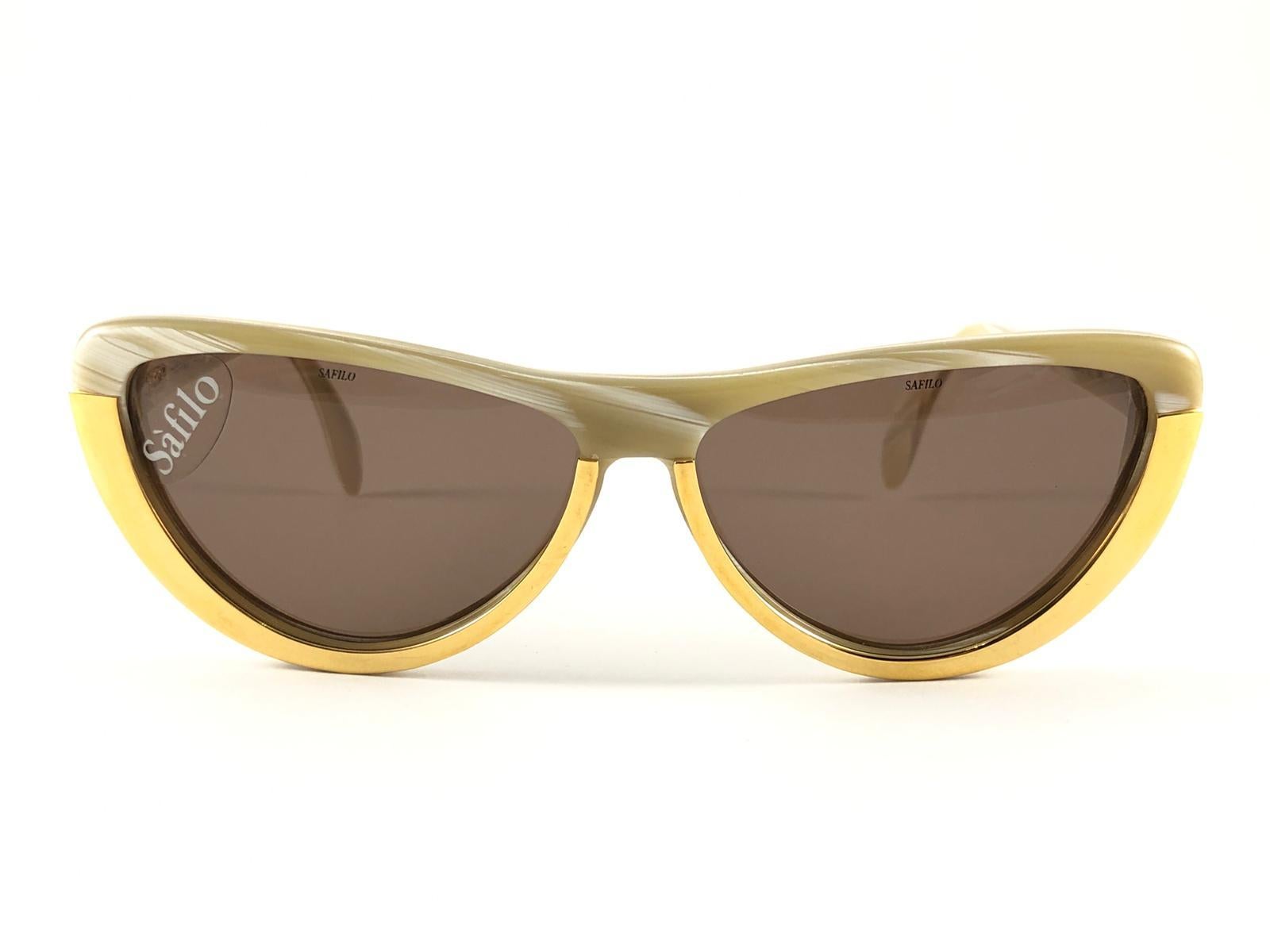 New Vintage Safilo, une combinaison équilibrée d'artisanat italien, de design, de fonctionnalité et d'esthétique frappante, ce modèle présente une monture marbrée et dorée et tient des verres marron moyen

Neuf, jamais porté ou exposé.
Fabriquées en