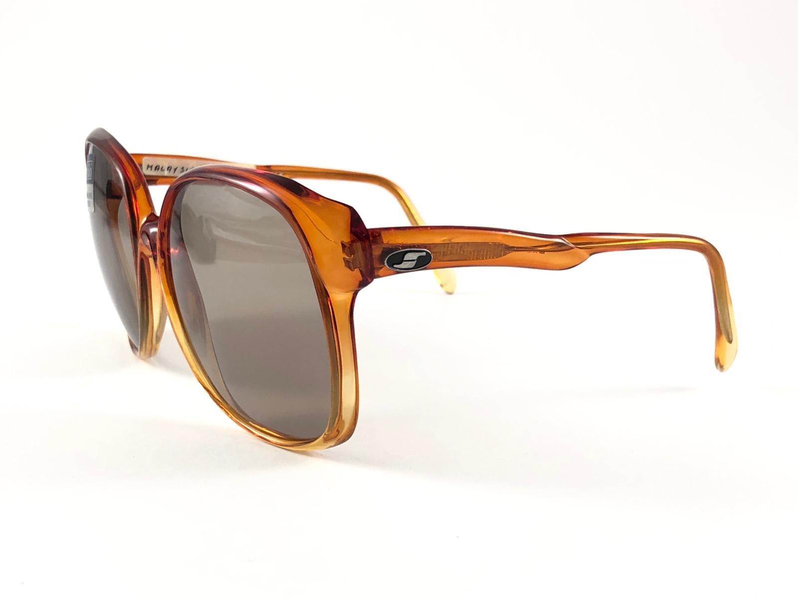 New Vintage Safilo, a balanced combination of Italian craftsmanship, design, functionality and striking aesthetics, this model showcases a translucent amber frame holding amber lenses. 

New, never worn or displayed.
Made in