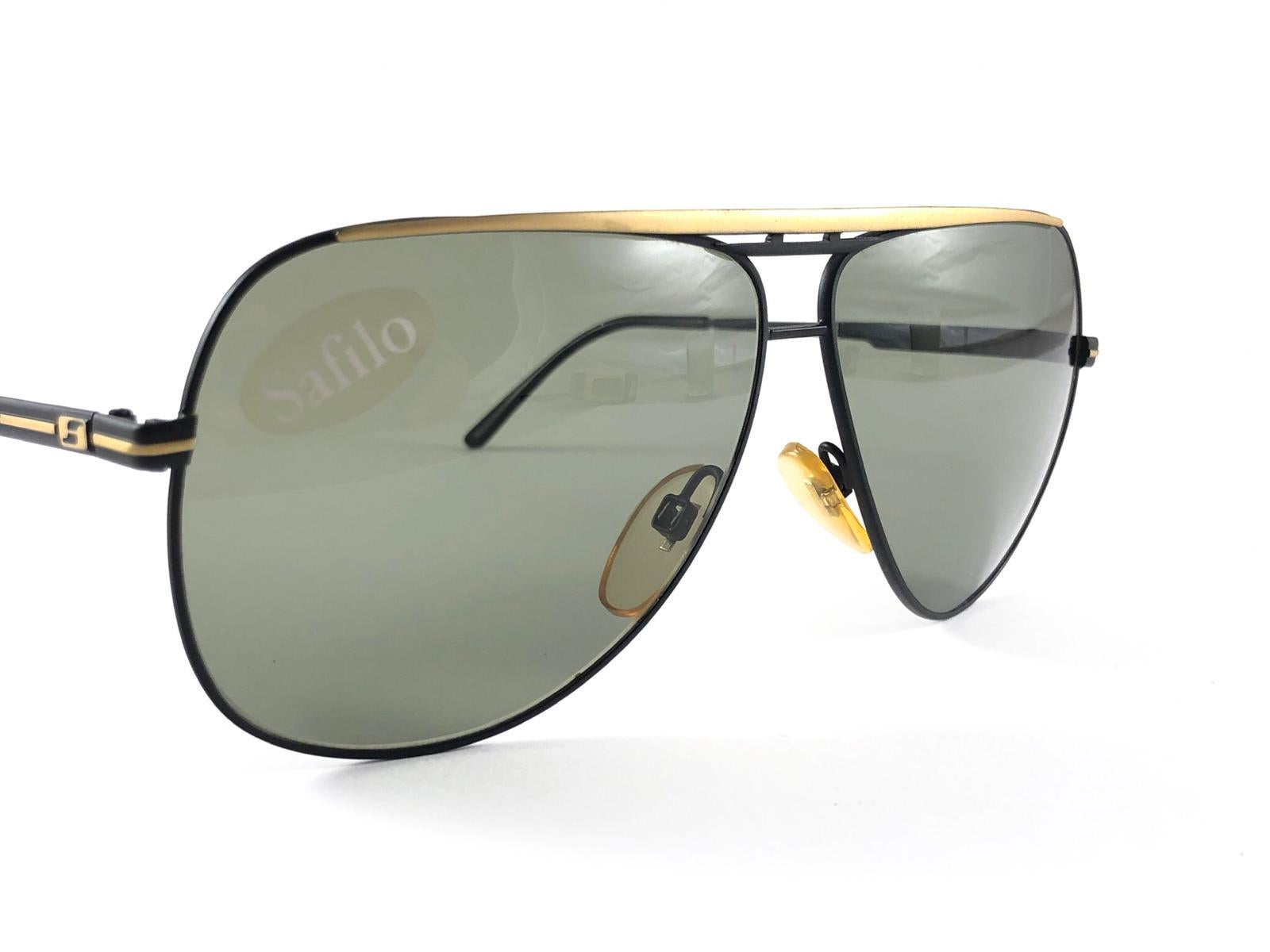 New Vintage Safilo, a balanced combination of Italian craftsmanship, design, functionality and striking aesthetics, this model showcases a Black and Gold mate Frame holding a spotless green lenses.

New, never worn or displayed.
Made in