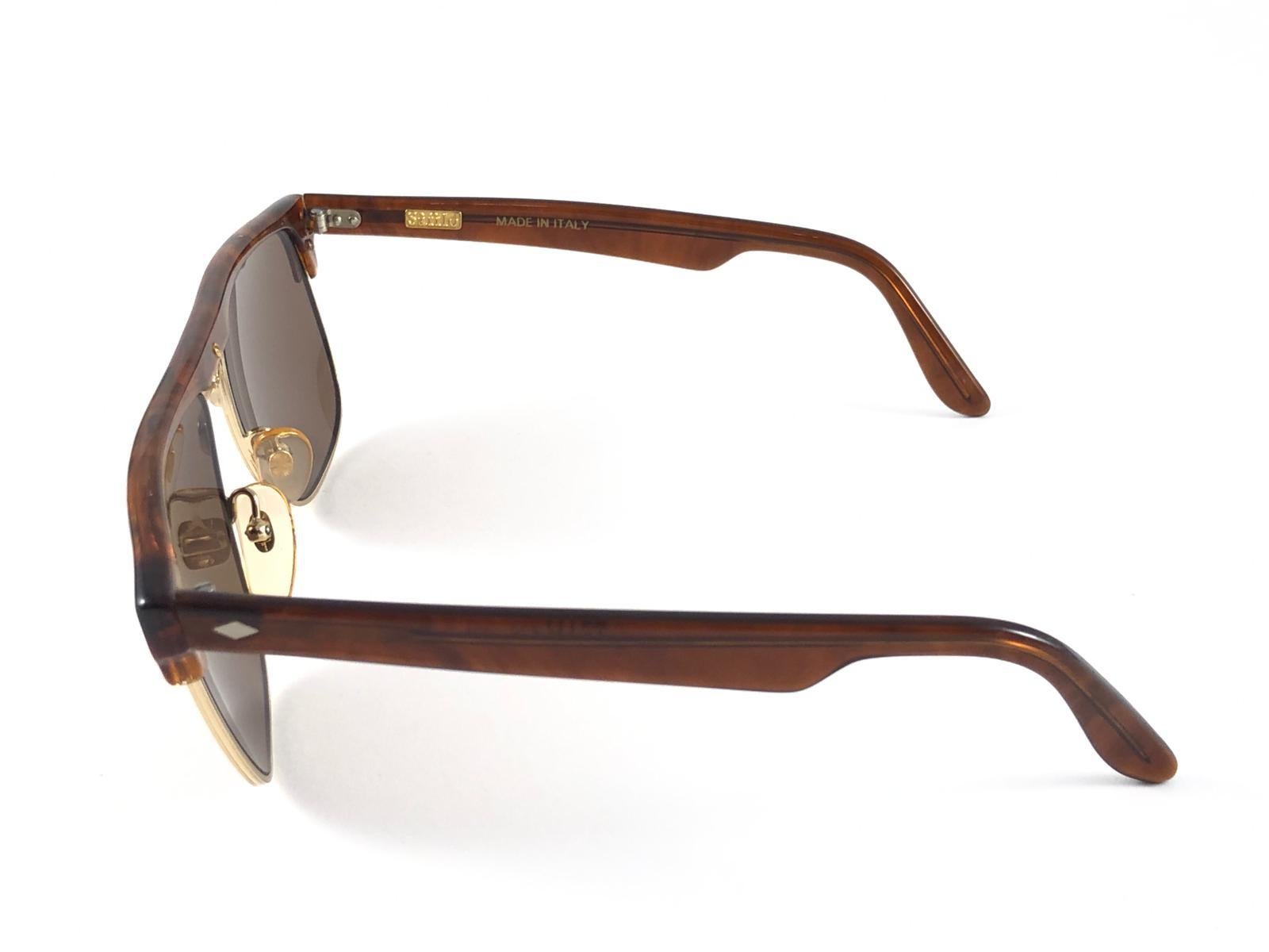 New Vintage Safilo, a balanced combination of Italian craftsmanship, design, functionality and striking aesthetics, this model showcases a Tortoise and Gold frame holding medium Brown lenses

New, never worn or displayed.
Made in
