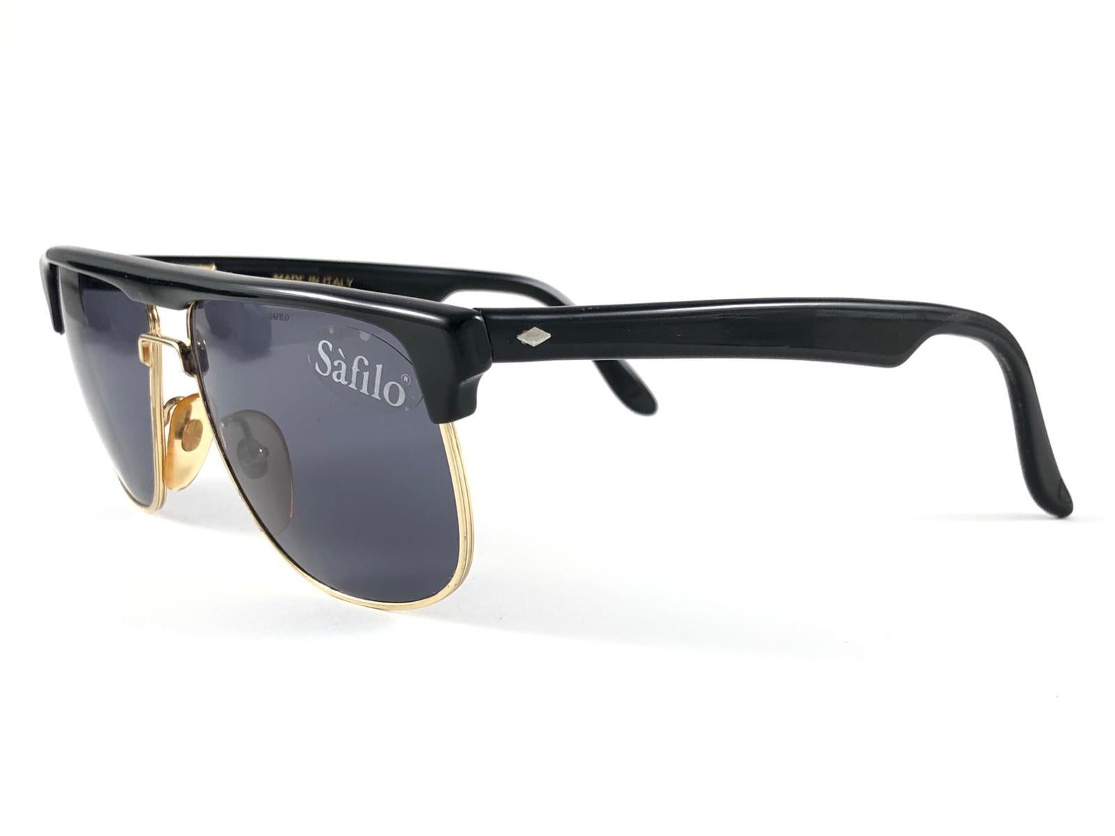 New Vintage Safilo, a balanced combination of Italian craftsmanship, design, functionality and striking aesthetics, this model showcases a black and gold frame and holds a grey lenses

New, never worn or displayed.
Made in Italy.

Measurements 