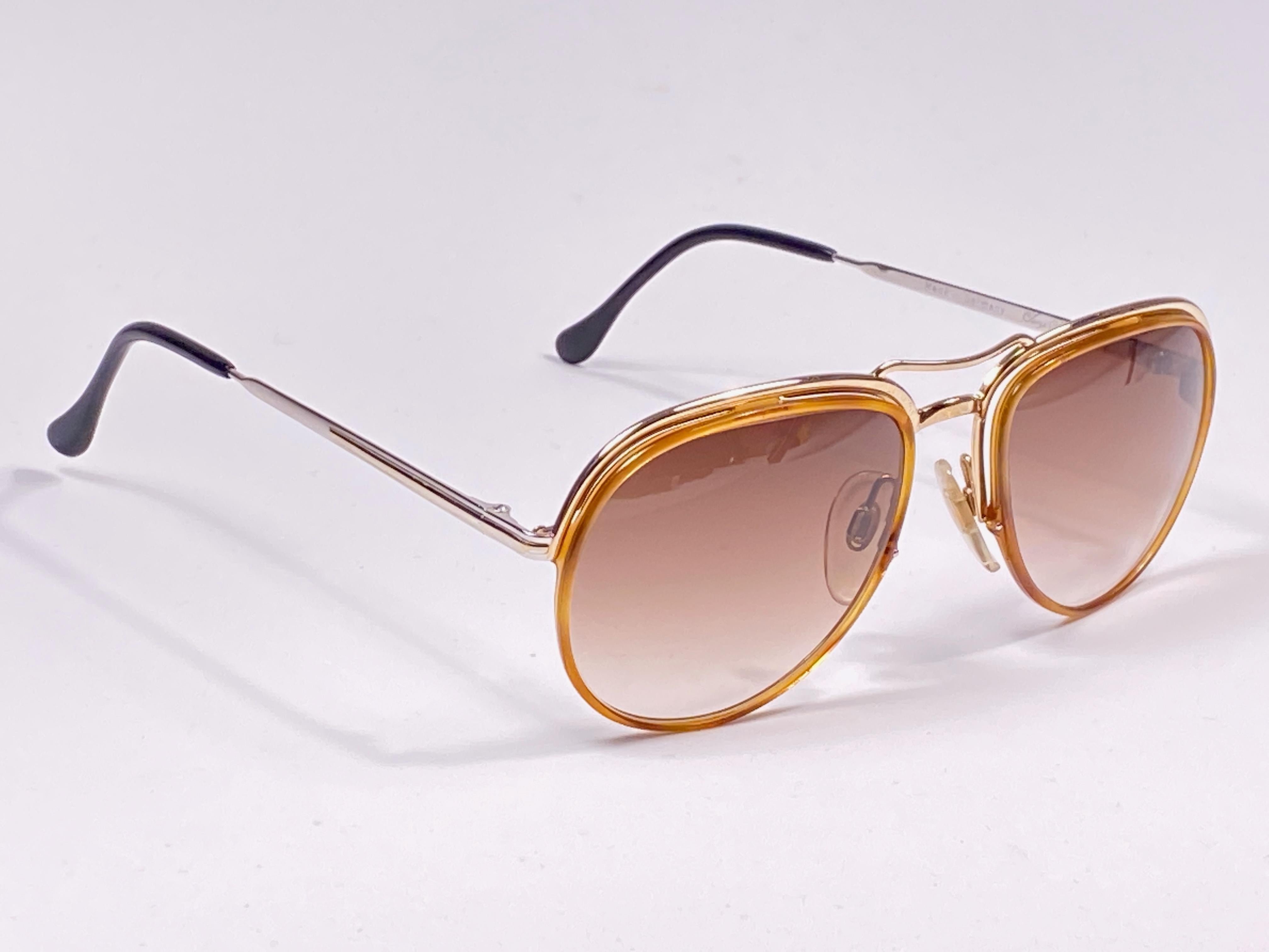 New vintage Serge Kirchhofer sunglasses. 

Spotless amber lenses.

This item may show sign of wear due to storage.

Made in Austria.


FRONT : 14 CMS

LENS WIDTH :  5.5 CMS

LENS HEIGHT : 4.5 CMS
