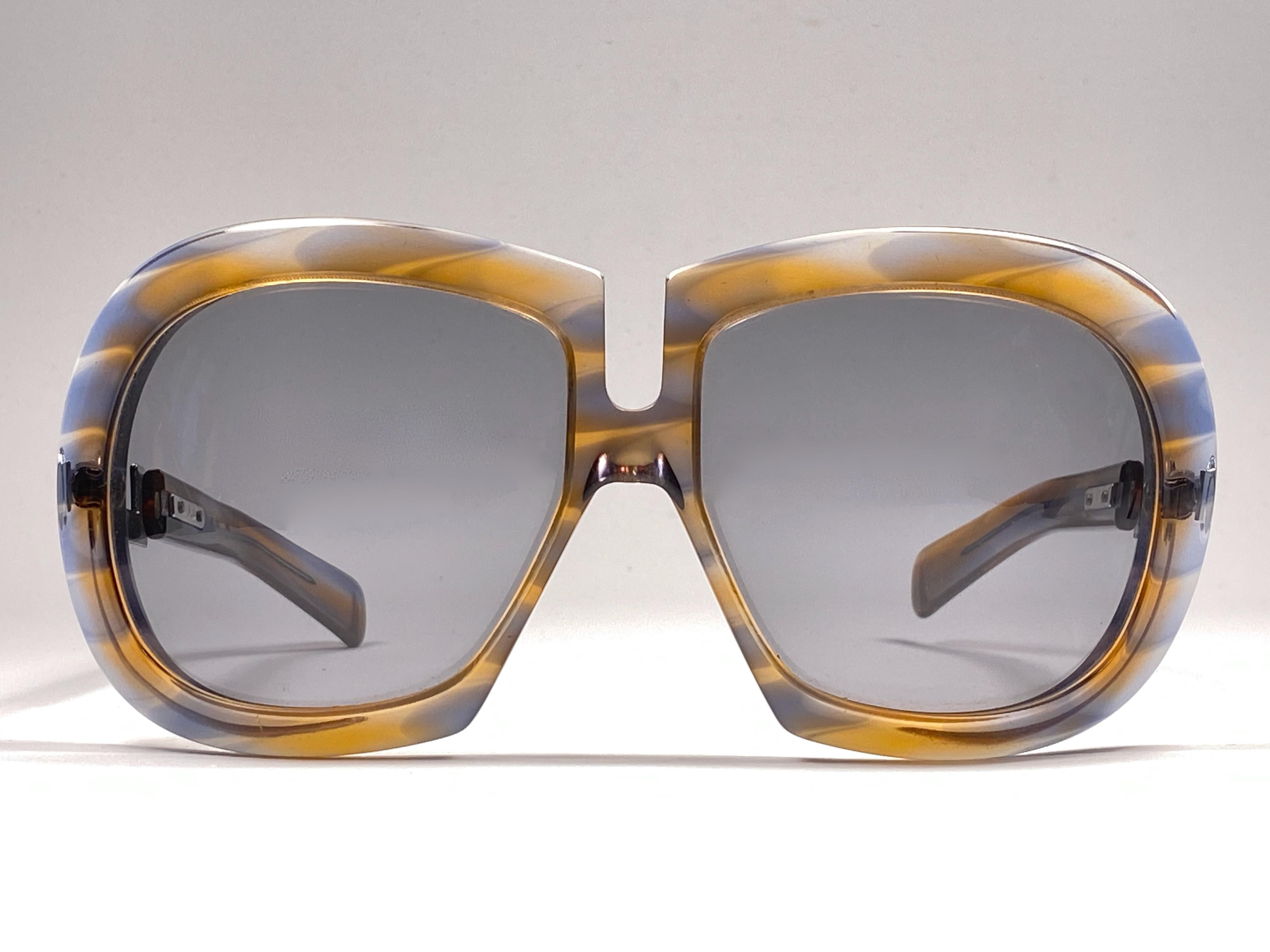 New Vintage Collector Item Silhouette Clear Colours and Silver accents  Monture de lunettes de soleil avec une paire de verres gris moyen impeccables.   

Fabriqué en Allemagne dans les années 1970.

AVANT : 15.5 CMS

HAUTEUR DE LA LENTILLE : 5