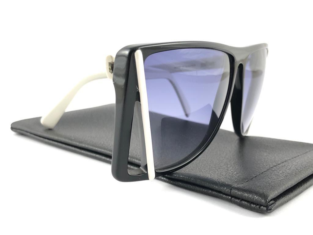 New Vintage Silhouette black with white accents sunglasses. Cut out frame sporting a pair of purple lenses.

Never worn or displayed. This item may show minor sign of wear due to nearly 40 years of storage.

Designed and produced in Austria.

FRONT