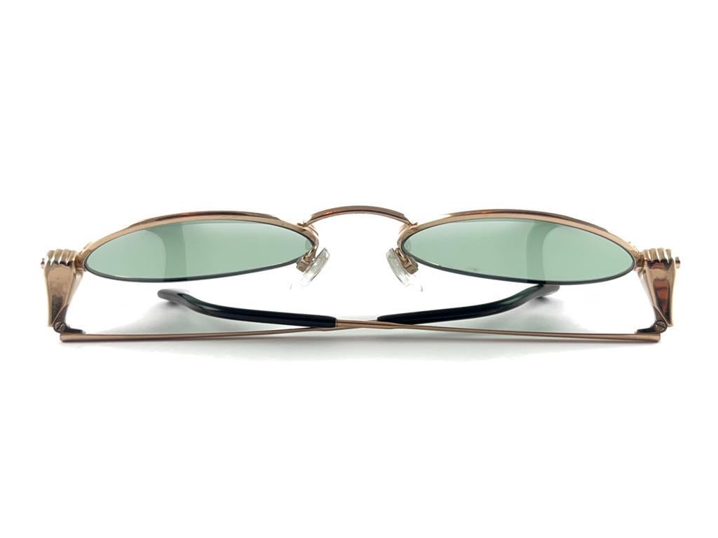 Uber Cool Silhouette Sunglasses. Gold Oval Frame With Racing Hands Ornaments Holding A Pair Of Medium Green Lenses.



Frame Has Light Wear From 40 Years Of Storage.



Superb Quality,  Even Better Design.



Made In Austria.







Front : 14