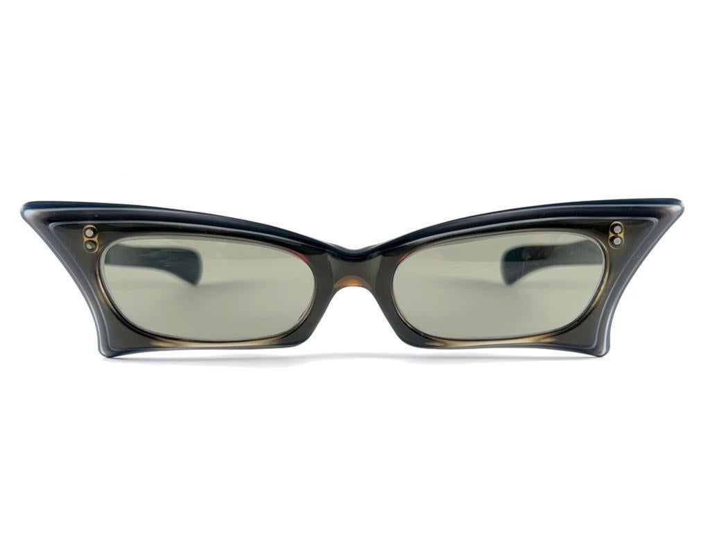 

Vintage Petites lunettes de soleil rectangulaires Midcentury Holding a pair of light Green Lenses Sunglasses 1960's 
Cette paire peut présenter des signes mineurs d'usure dus à plus de 50 ans de stockage.



Fabriqué en France



Avant            