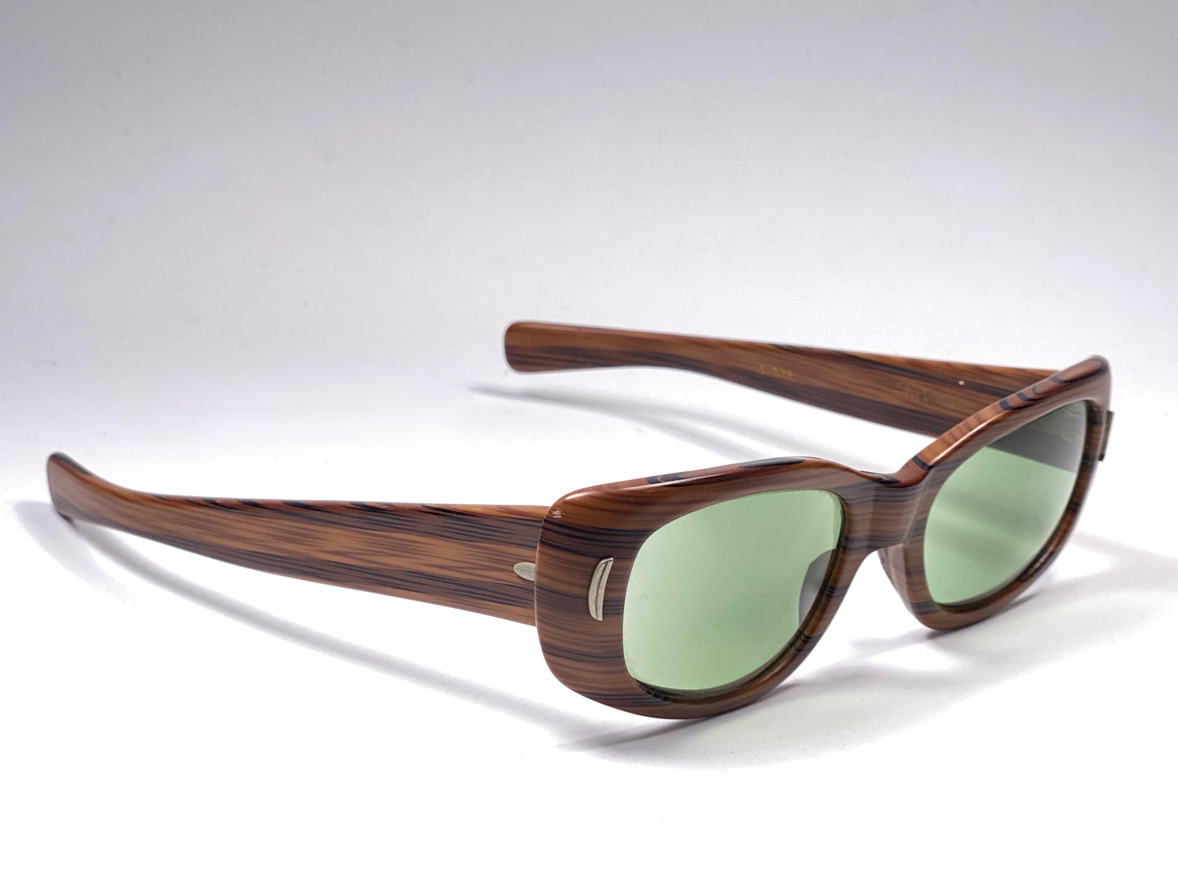New Vintage Suntimer Victory sunglasses. Iconic striped wood resemblance frame with G15 grey lenses.

Please notice this item its almost 60 years old and may show minor sign of wear due to storage.

An original and seldom piece.