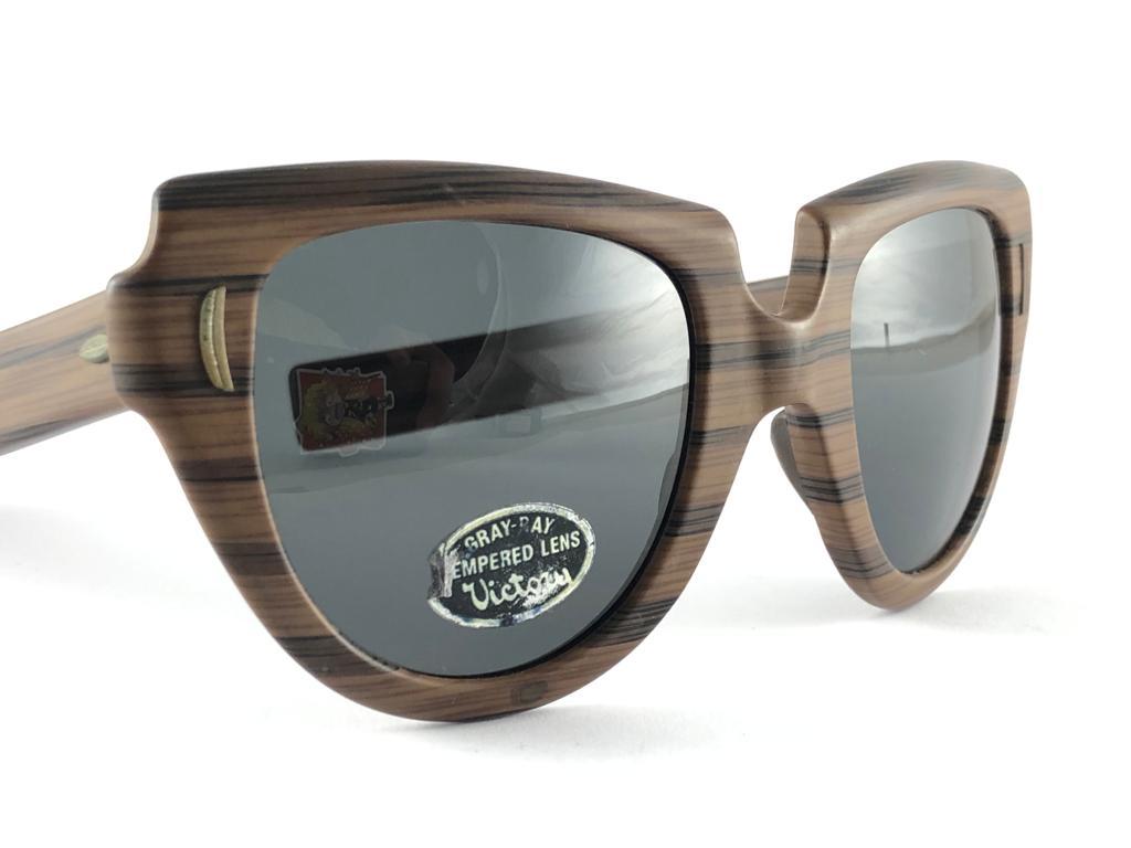 New Vintage Suntimer Victory sunglasses. Iconic striped wood resemblance frame with G15 grey lenses.

Please notice this item its almost 60 years old and may show minor sign of wear due to storage.

This item may show some minor sign of wear due to