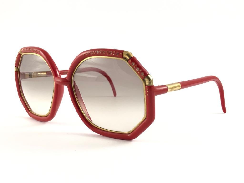 Mint Vintage Ted Lapidus red & gold frame with rhinestones accents spotless brown gradient lenses.  
Made in Paris.  
Produced and design in 1970's.  
This item have sign of wear on the frame in a form or small tarnish on the gold. Please study the