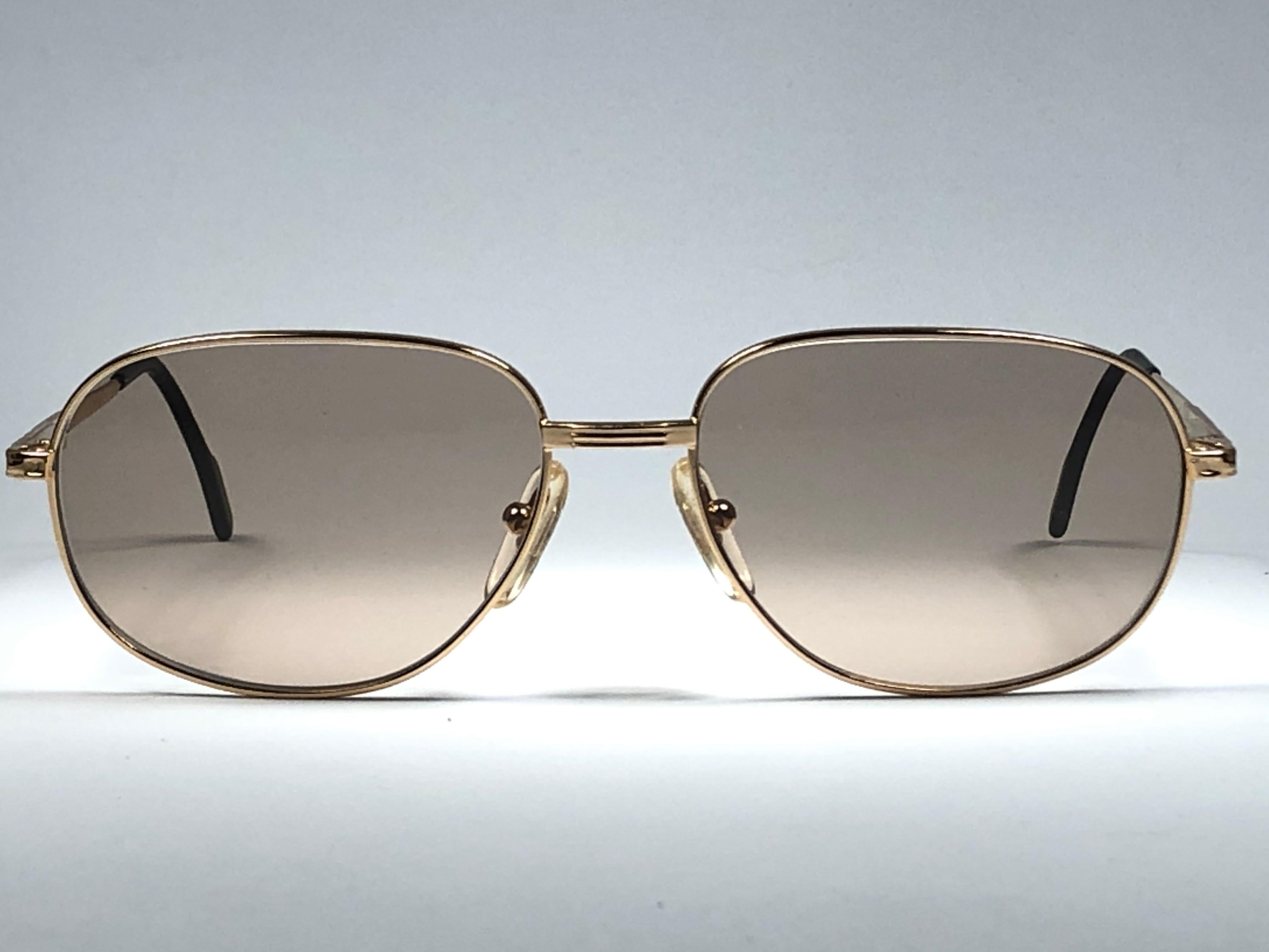 Nuevo marco chapado en oro Tiffany. Lentes marrones degradadas sin manchas.

Fabricado en Italia.
 
Producido y diseñado en la década de 1990.

Este artículo puede mostrar pequeños signos de desgaste debido al almacenamiento.