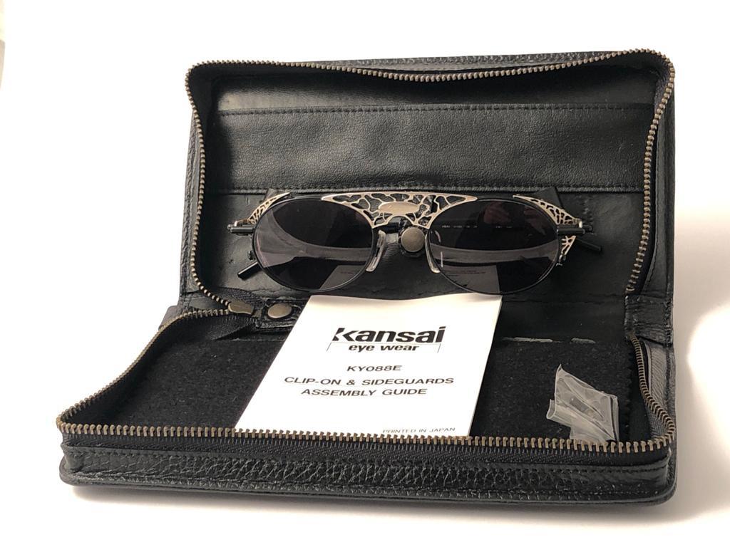 Cult designer Kansai signed this ultra chic pair of heavily detailed sunglasses.

Spotless medium grey  lenses.  removable side leather cups.

Superior quality and design. 

A seldom piece in this condition, Full  Set.

This item show minor sign of